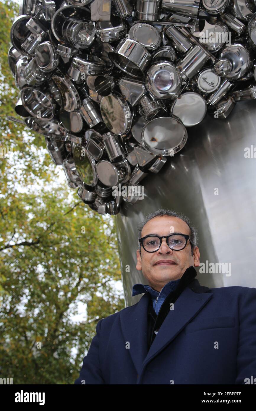 Der Künstler Subodh Gupta posiert für Fotos vor seiner neuen Installation Soak becomes Spill, die sechs Meter hoch mit einem Topf überfüllt steht Stockfoto