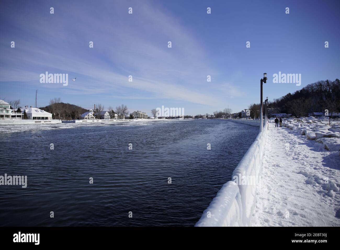 Grand HAVEN, Michigan, Februar 2021, Eisbedeckte Geländer und Laternenpfosten, entlang der verschneiten Spur des Piers, Winterwasser Stockfoto