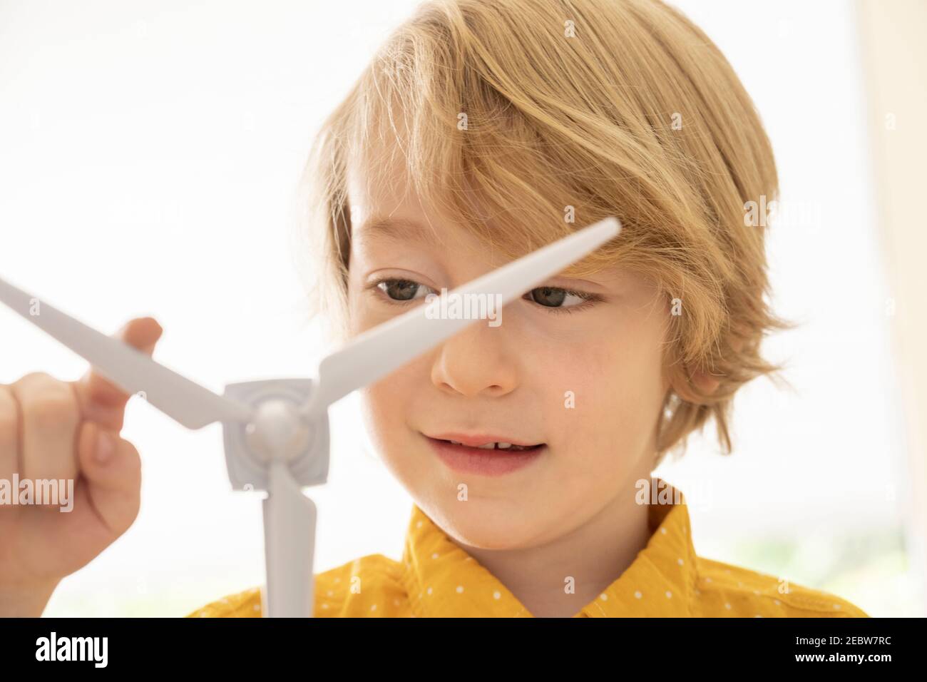 Junge (6-7) spielt mit Windturbinenmodell Stockfoto