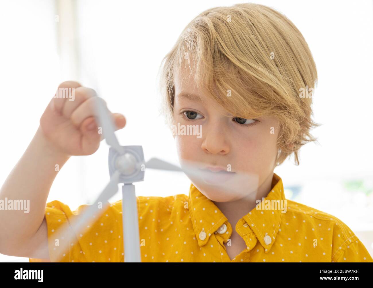 Junge (6-7) spielt mit Windturbinenmodell Stockfoto