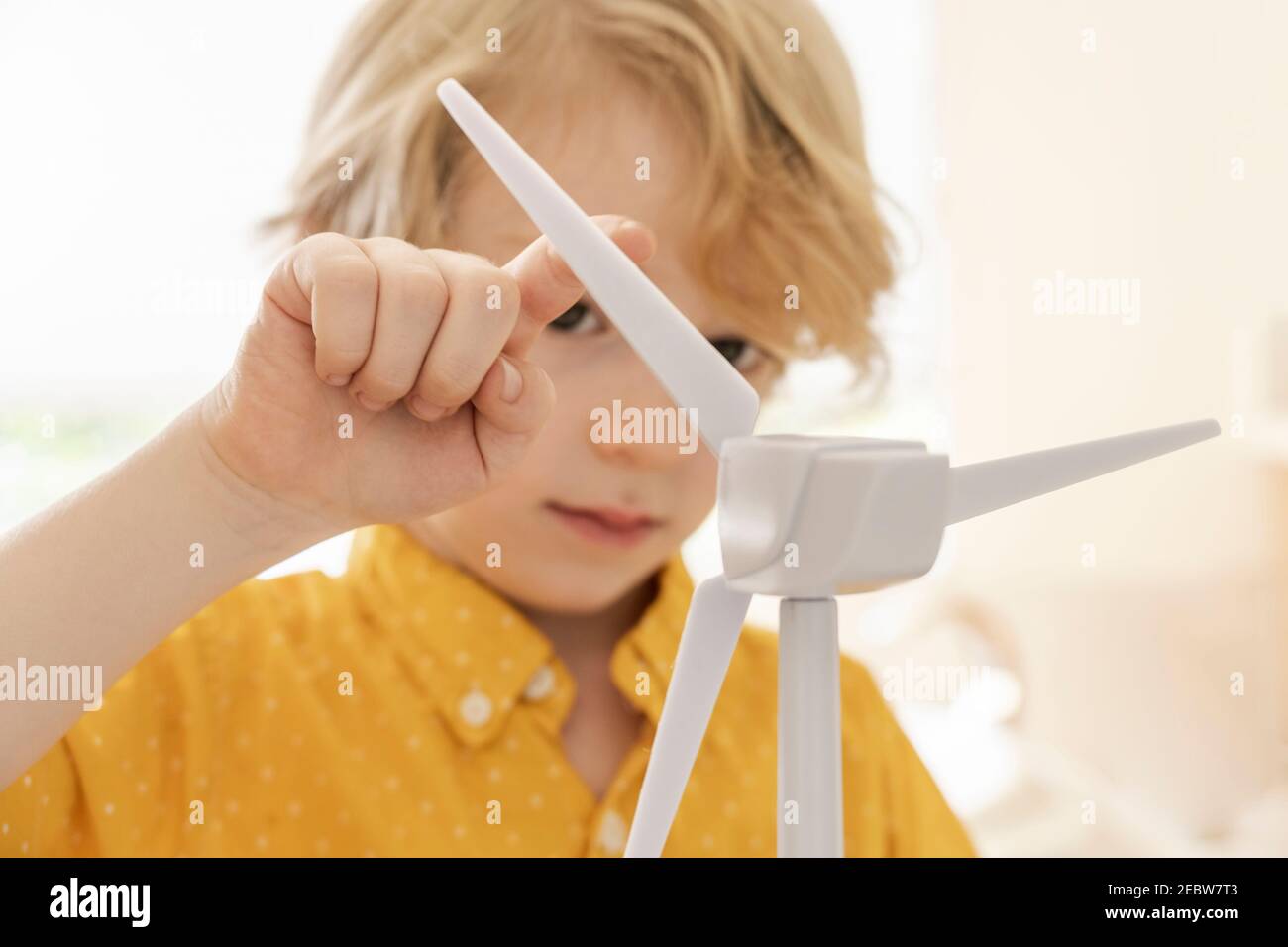 Junge (6-7) spielt mit Windturbinenmodell Stockfoto