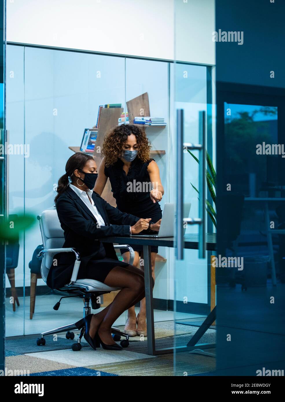 Geschäftsfrauen tragen Masken im Büro Stockfoto