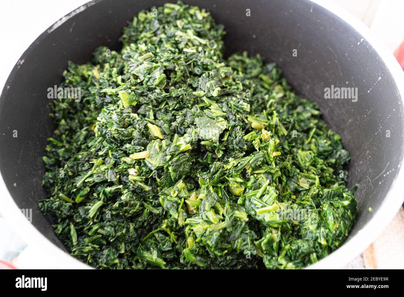 Gewaschene Gemüsespinat im Topf, um nigerianische Gemüsesuppe zu machen Stockfoto