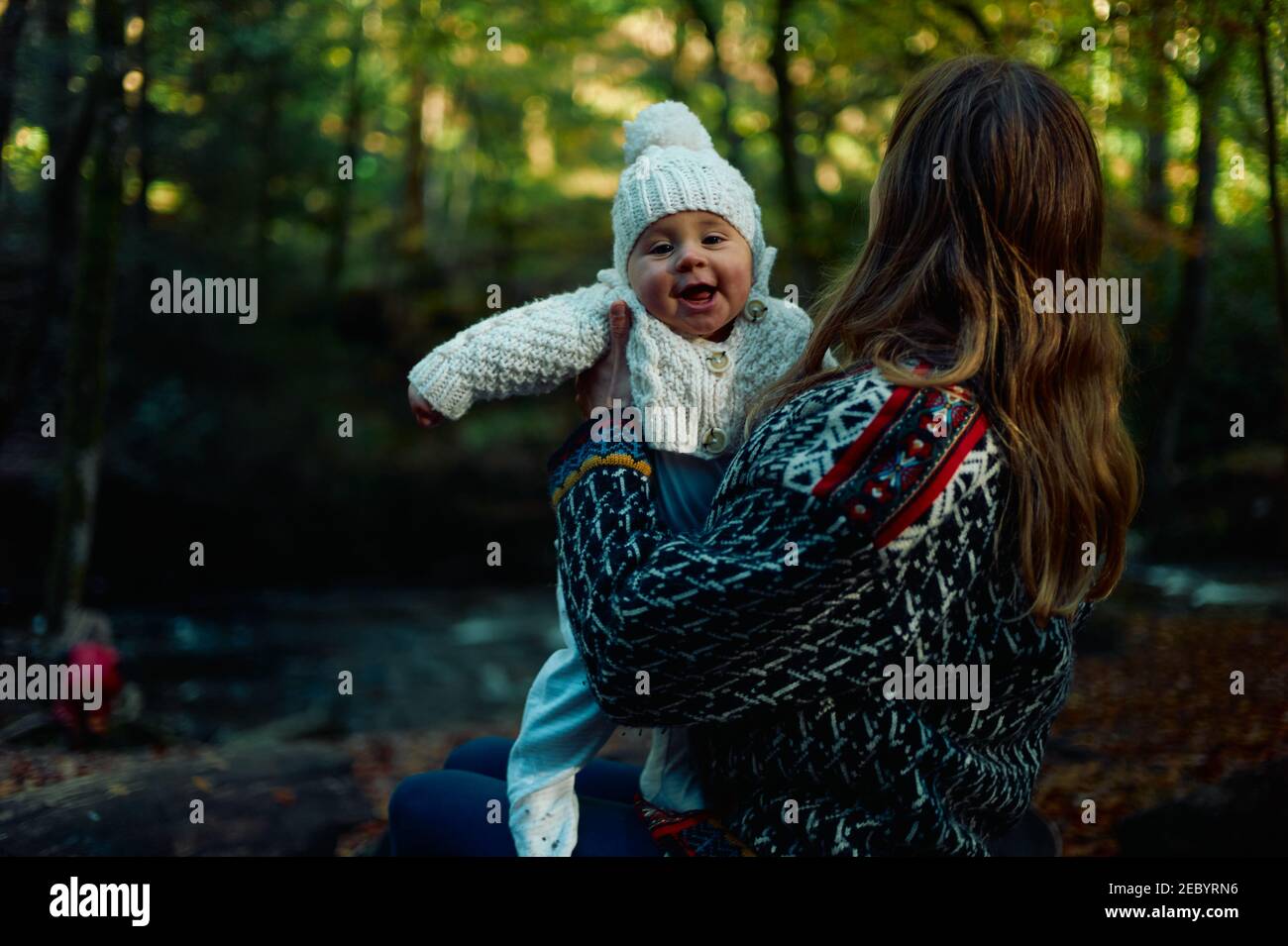 Eine junge Mutter ist mit ihrem Baby im Wald An einem sonnigen Herbsttag Stockfoto