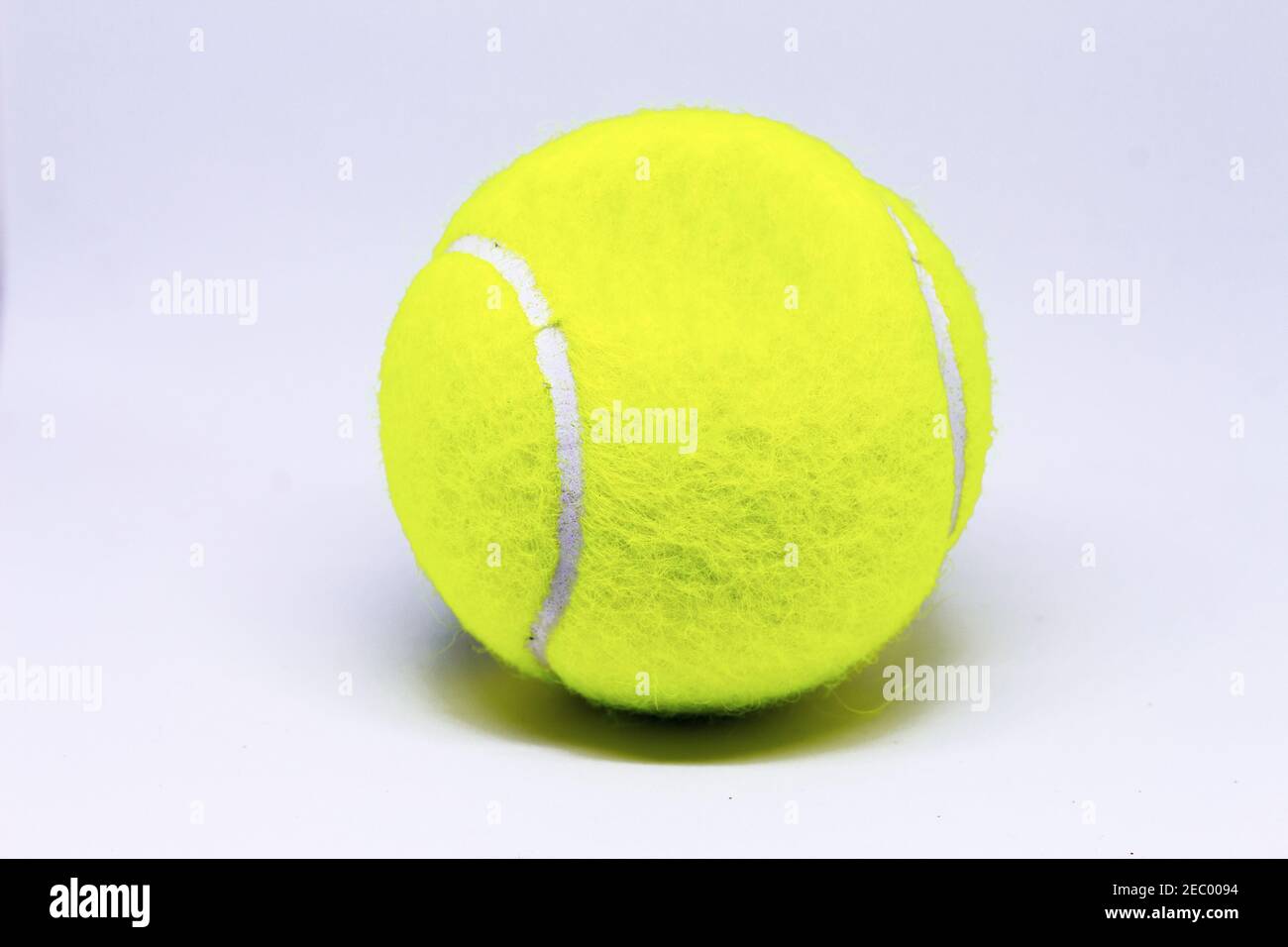 Gelb Tennisball isoliert auf weißem Hintergrund. Tennis Ball Foto für Banner Vorlage. Sportausrüstung isoliert. Tenniswettbewerb im Hintergrund. Gelb Stockfoto