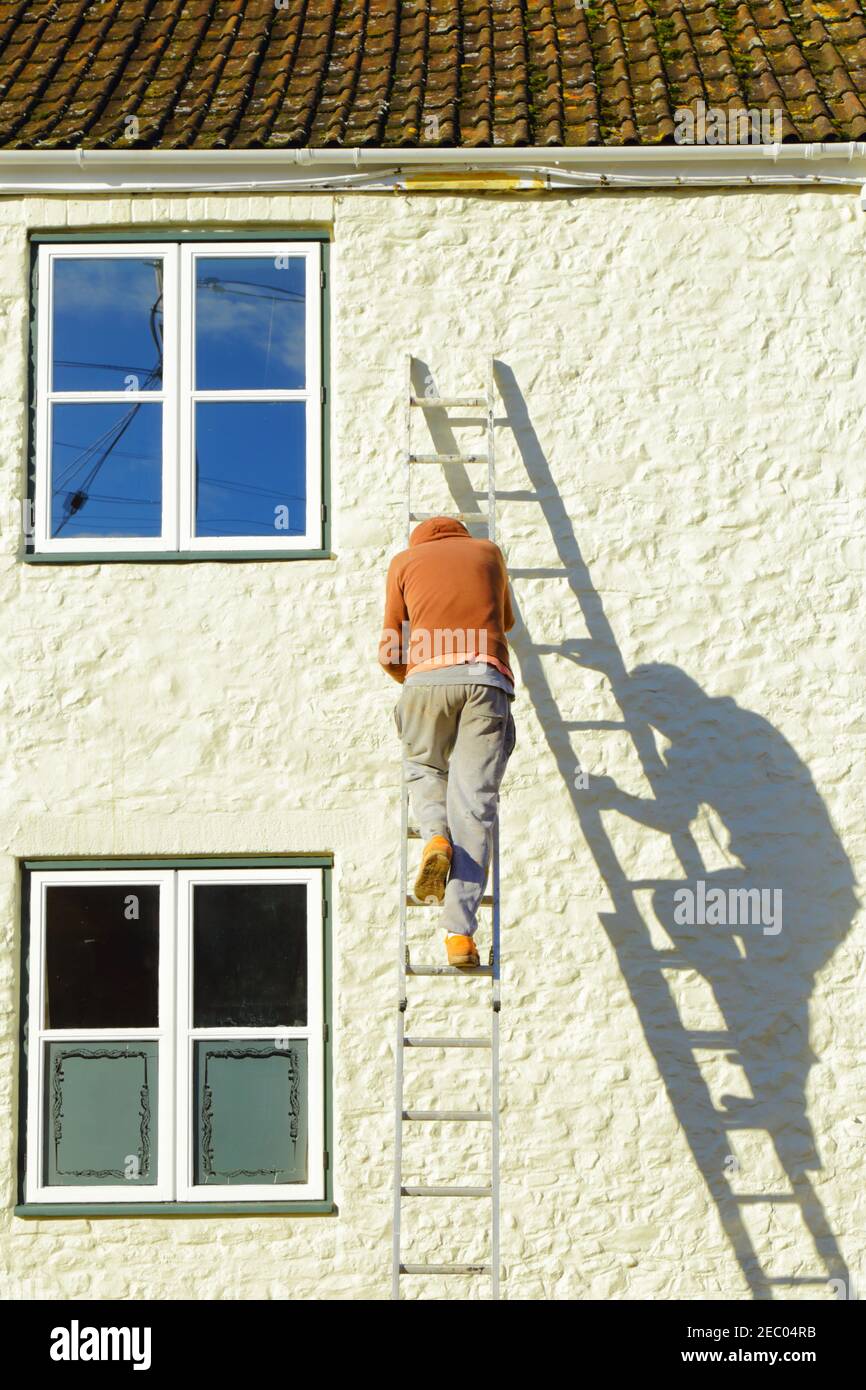 Mann, der auf der Leiter steht Stockfoto