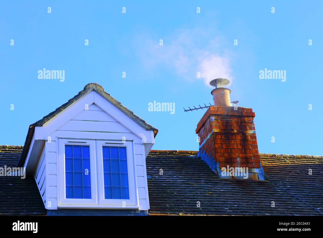 Rauch aus dem Kamin gegen blauen Himmel Stockfoto