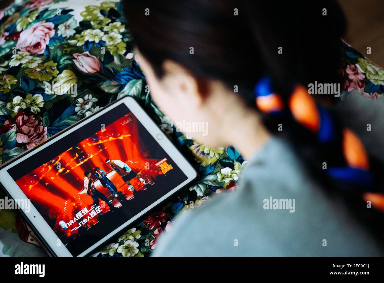 (210213) -- SHANNAN, 13. Februar 2021 (Xinhua) -- Kelyang sieht sich einen Videoclip über Rap-Musik auf einem Tablet-Computer in ihrem Haus in Shannan in der Autonomen Region Tibet im Südwesten Chinas an, 10. Februar 2021. Der 12. Februar markiert den ersten Tag des tibetischen Neujahrs, der mit dem diesjährigen Frühlingsfest zusammenfiel. Am frühen Morgen zog Kelyang, 23, traditionelle tibetische Kostüme an und ging mit ihren Eltern zum Gebet durch die Berge.als Postgraduierte-Studentin der Beijing Normal University mit Schwerpunkt auf moderner und zeitgenössischer chinesischer Literatur liebt Kelyang Rap-Musik, schaut sich online Videos an und schreibt Stockfoto