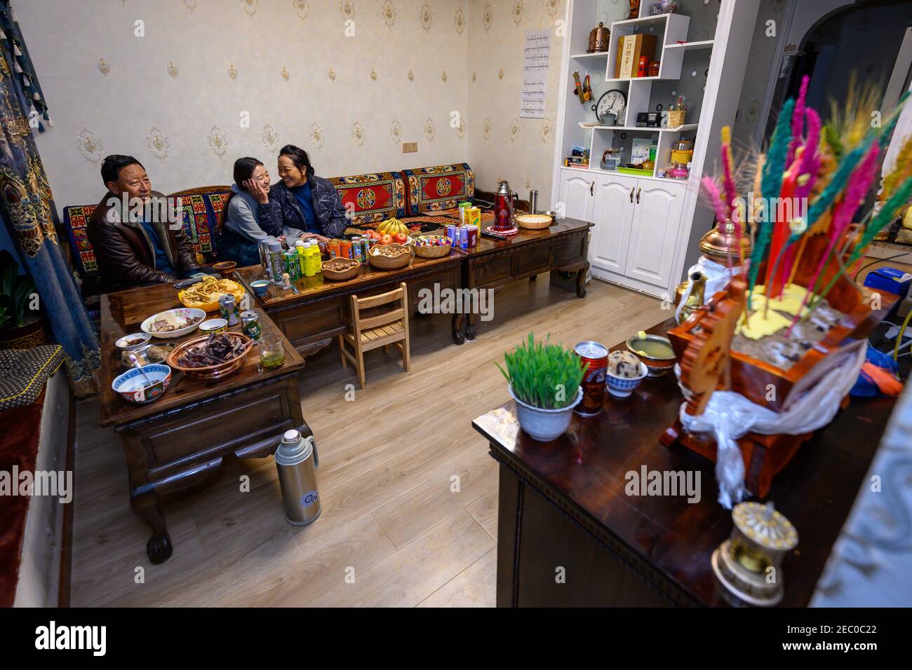 (210213) -- SHANNAN, 13. Februar 2021 (Xinhua) -- Kelyang (C) und ihre Familie sehen die Gala des Frühlingsfestes im Fernsehen zu Hause in Shannan, der autonomen Region Tibet im Südwesten Chinas, am 11. Februar 2021. Der 12. Februar markiert den ersten Tag des tibetischen Neujahrs, der mit dem diesjährigen Frühlingsfest zusammenfiel. Am frühen Morgen zog Kelyang, 23, traditionelle tibetische Kostüme an und ging mit ihren Eltern zum Gebet durch die Berge.als Postgraduierte-Studentin der Beijing Normal University mit Schwerpunkt auf moderner und zeitgenössischer chinesischer Literatur liebt Kelyang Rap-Musik, schaut sich Videos online an und liest Stockfoto