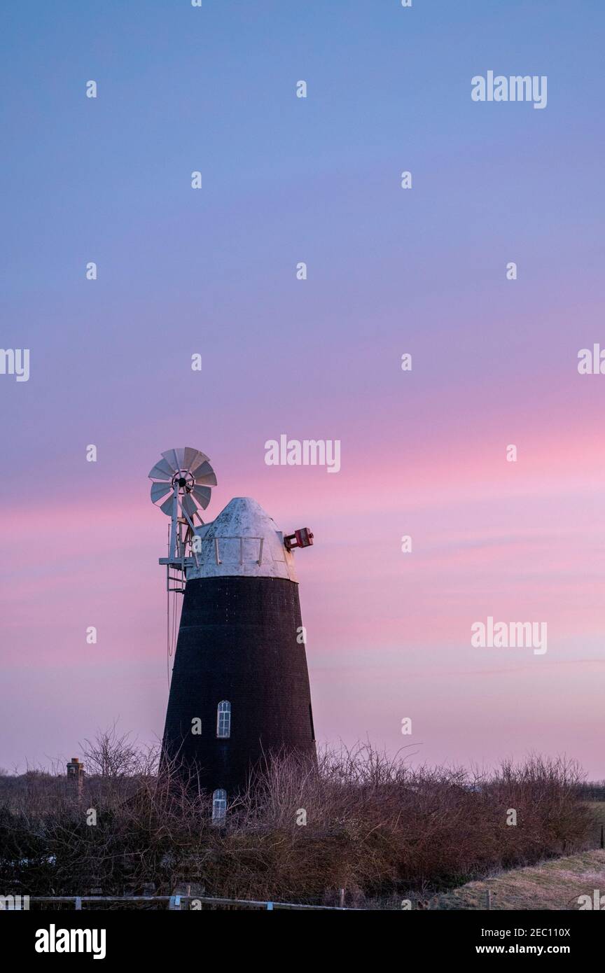 Über Cambridgeshire, Großbritannien. Februar 2021, 13th. Der Himmel leuchtet rosa hinter einer stillstehenden Windmühle an einem frostigen Morgengrauen. Die Temperaturen fielen auf minus 3C über Nacht. Der Kälteschnall soll in den nächsten Tagen enden. Kredit: Julian Eales/Alamy Live Nachrichten Stockfoto