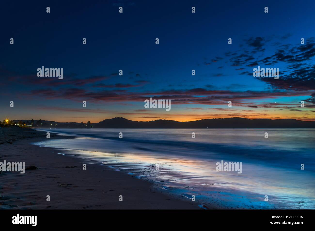 Sonnenaufgang am Strand mit schimmerndem blauem Wasser am Umina Beach an der Central Coast, NSW, Australien. Stockfoto