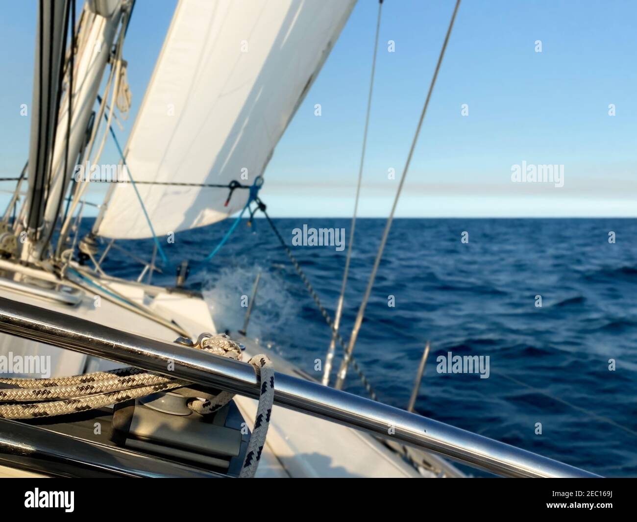 Yacht segelt an einem ruhigen und sonnigen Tag von den Köpfen des Hafens von Sydney ab. Blick vom Cockpit des Bootes über den Horizont, mit ruhigem Ozean vor sich Stockfoto