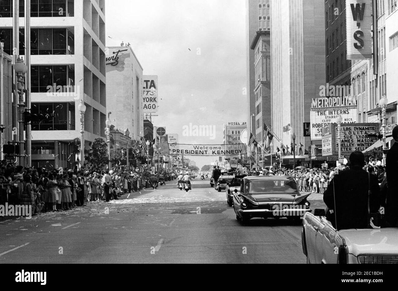 Besichtigung der NASA-Installationen: Houston, Texas, Autokolonne, Adresse an der Rice University, 9:34am Uhr. Präsident John F. Kennedy (Mitte rechts, im Hintergrund) steht in der Präsidentenlimousine (Lincoln-Mercury Continental Cabrio), während seine Autokolonne die Main Street in Houston, Texas, auf dem Weg zur Rice University entlang fährt. Konfetti fällt auf die Autokolonne, Menschenmassen säumen die Straße. Stockfoto