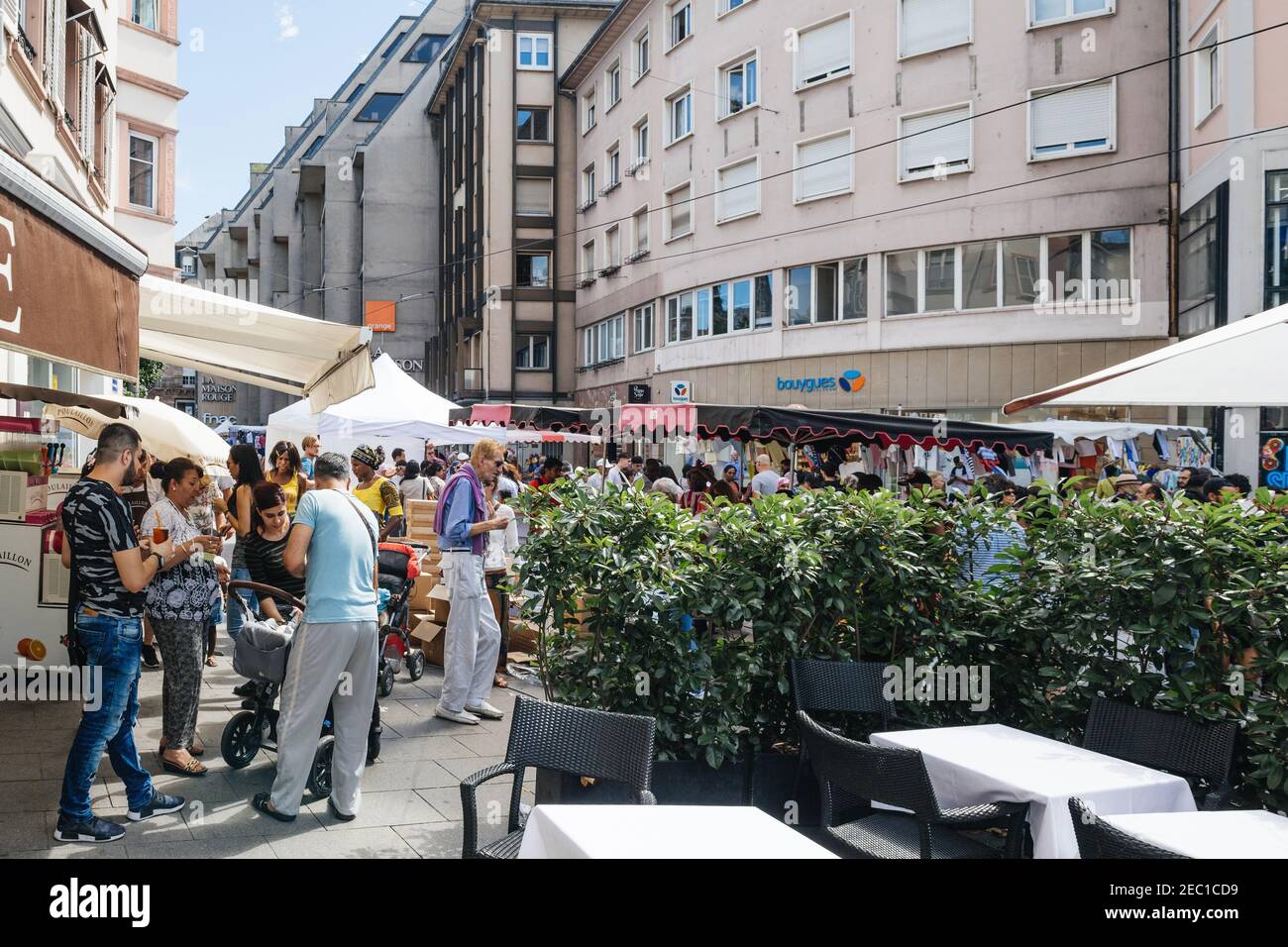 Straßburg, Frankreich - 29. Juli 2017: Große Menschenmenge, die in der Nähe der Straßenbahnhaltestelle Homme de Fer und der Geschäfte während der Grande Braderie Straßenmesse jährlichen Verkaufsveranstaltung läuft - Freunde trinken draußen Biergläser Stockfoto