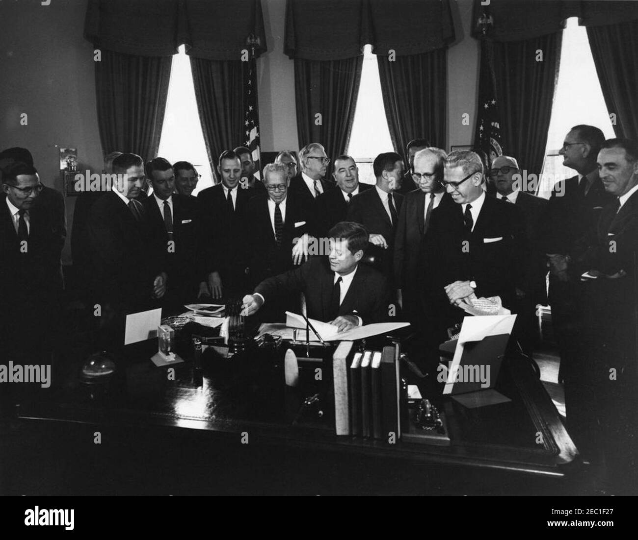 Bill Signing - S. 1991 Öffentliches Recht 415, Manpower Development u0026 Training Act, 10:31am. Präsident John F. Kennedy (am Schreibtisch sitzend) unterzeichnet den Manpower Development and Training Act (Öffentliches Recht 415). Blick auf (L-R): Senator Winston L. Prouty (Vermont); Kongressabgeordneter Neal Smith (Iowa); Senator Maurice J. Murphy, Jr. (New Hampshire); Kongressabgeordneter Charles S. Joelson (New Jersey); Kongressabgeordneter Charles E. Goodell (New York); Kongressabgeordneter Peter A. Garland von Maine (teilweise versteckt); Kongressabgeordneter Carroll D. Kearns (Pennsylvania); Direktor des Department of Legislation der American Federation of La Stockfoto