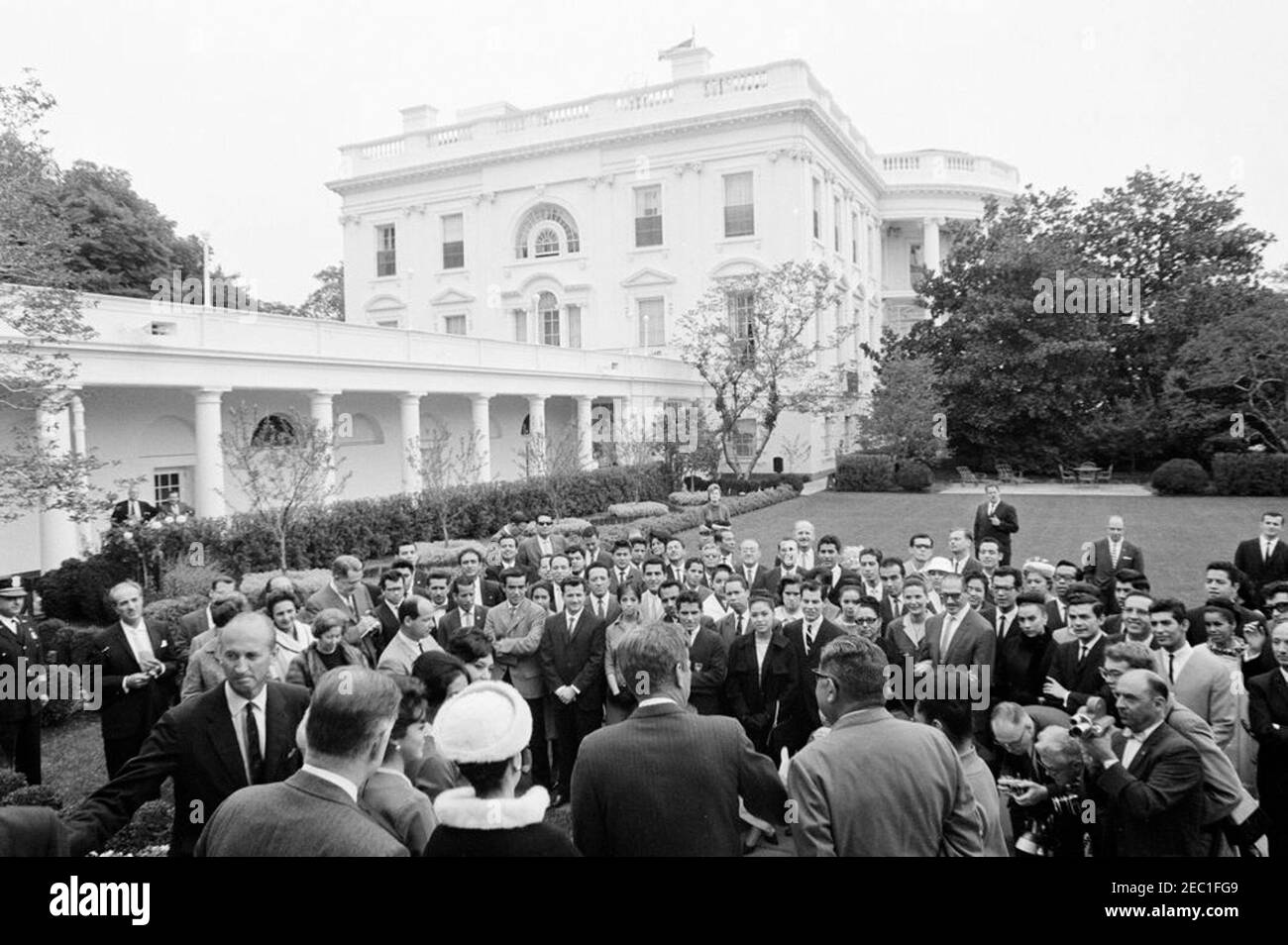 Besuch der Mitglieder des Ballet Folklorico von Mexiko, 12:41pm Uhr. Präsident John F. Kennedy (Mitte) spricht Mitglieder des Ballet Folklorico von Mexiko. Zu den Präsidenten Kennedy gehören: Protokollchef Angier Biddle Duke; stellvertretender Staatssekretär für interamerikanische Angelegenheiten, Edwin M. Martin; Botschafter von Mexiko, Antonio Carrillo Flores. Rose Garden, White House, Washington, D.C. Stockfoto