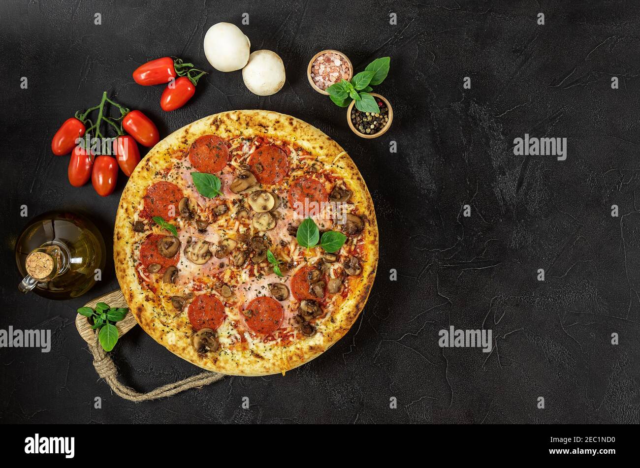 Heiße italienische Napoli-Pizza mit Schinken und Pilzen im Dunkeln Hintergrund Stockfoto