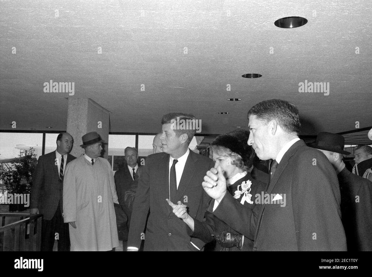 Dedication Ceremonies, Dulles International Airport, 11:12am Uhr. Präsident John F. Kennedy (Mitte) und ehemaliger Präsident, General Dwight D. Eisenhower (meist versteckt hinter Präsident Kennedy), besichtigen das Terminalgebäude des Dulles International Airport bei Einweihungszeremonien für den Flughafen, der nach dem verstorbenen Außenminister John Foster Dulles benannt wurde. Aline B. Saarinen (Witwe des Architekten für den Flughafen, Eero Saarinen) und Administrator der Federal Aviation Agency (FAA), Najeeb Halaby, stehen rechts vom Präsidenten; Stellvertretender Administrator der FAA, Generalleutnant Harold W. Grant (mostl Stockfoto