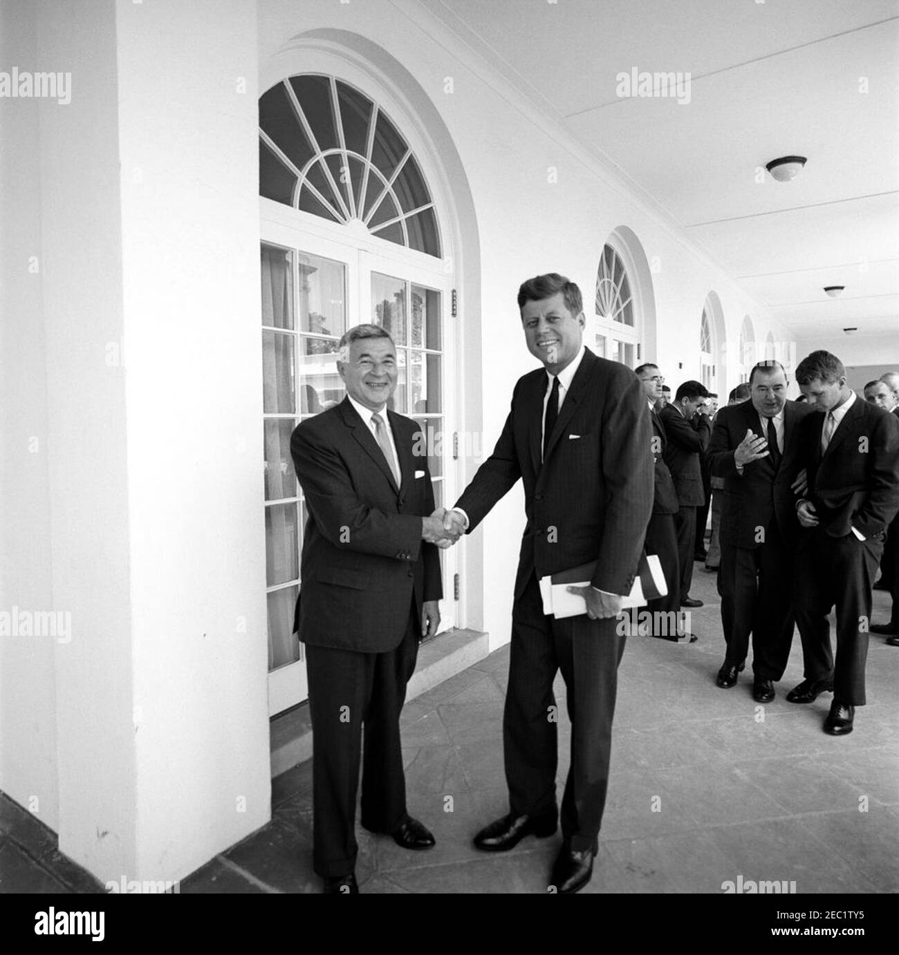 Präsident Kennedy mit dem Vertreter Leonard Farbstein (New York). Präsident John F. Kennedy schüttelt die Hände mit dem Vertreter Leonard Farbstein (New York) nach der Vorlage eines Berichts des Ausschusses für Jugendkriminalität Presidentu0027s; Vertreter Farbstein und andere Mitglieder des Ausschusses präsentierten den Bericht Präsident Kennedy. Rechts spricht Senator Jennings Randolph (West Virginia) mit Generalstaatsanwalt Robert F. Kennedy; alle anderen sind nicht identifiziert. West Wing Colonnade, White House, Washington, D.C. Stockfoto