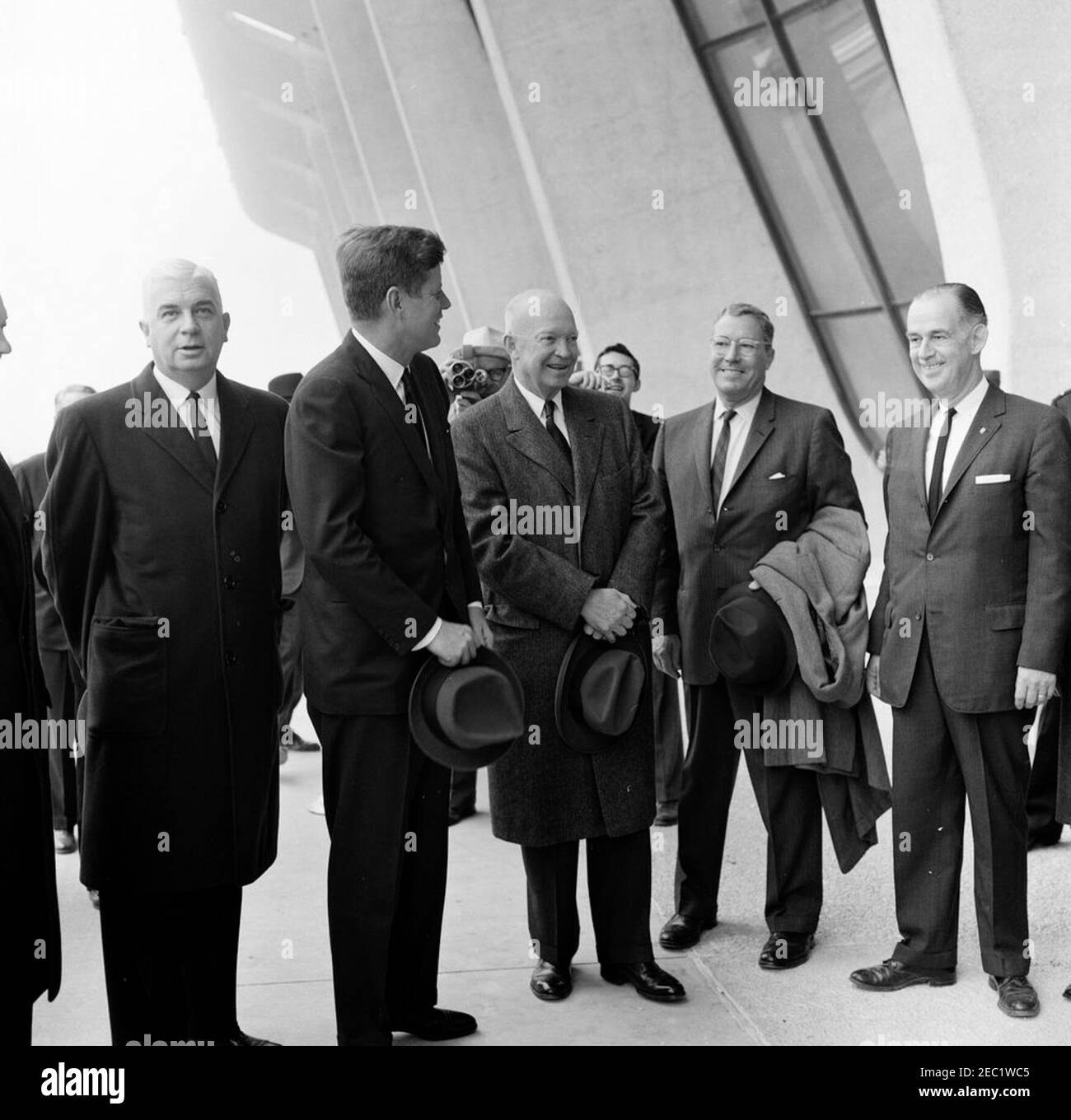 Dedication Ceremonies, Dulles International Airport, 11:12am Uhr. Präsident John F. Kennedy und der ehemalige Präsident, General Dwight D. Eisenhower, nehmen an der Einweihungszeremonie für den internationalen Flughafen Dulles Teil, benannt nach dem verstorbenen Außenminister John Foster Dulles. Von links nach rechts: Gouverneur von Virginia, Albertis S. Harrison, Jr.; Präsident Kennedy (mit Hut); General Eisenhower; ehemaliger Administrator der Federal Aviation Agency (FAA), General Elwood R. u201cPeteu201d Quesada; Direktor des Bureau of National Capital Airports, G. ward Hobbs. Chantilly, Virginia. Stockfoto
