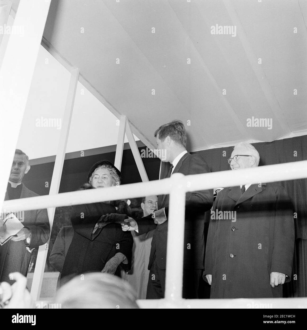 Dedication Ceremonies, Dulles International Airport, 11:12am Uhr. Präsident John F. Kennedy nimmt an der Einweihungszeremonie für den internationalen Flughafen Dulles Teil, benannt nach dem verstorbenen Außenminister John Foster Dulles; Präsident Kennedy (Mitte rechts) schüttelt die Hände mit Janet Avery Dulles, Witwe des ehemaligen Sekretärs Dulles. Der Kaplan des Senats der Vereinigten Staaten, Reverend Frederick Brown Harris, steht ganz links; der Oberste Richter des Obersten Gerichtshofs, Earl Warren, steht rechts. Chantilly, Virginia. Stockfoto