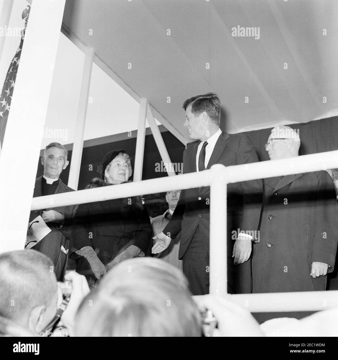Dedication Ceremonies, Dulles International Airport, 11:12am Uhr. Präsident John F. Kennedy nimmt an der Einweihungszeremonie für den internationalen Flughafen Dulles Teil, benannt nach dem verstorbenen Außenminister John Foster Dulles. Von links nach rechts: Kaplan des Senats der Vereinigten Staaten, Reverend Frederick Brown Harris; Janet Avery Dulles (Witwe des ehemaligen Sekretärs Dulles); nicht identifiziert (hinten); Präsident Kennedy; Oberrichter des Obersten Gerichtshofs, Earl Warren. Chantilly, Virginia. Stockfoto