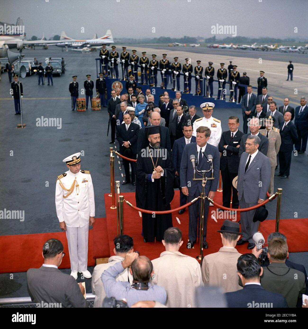 Zeremonie zur Ankunft von Erzbischof Makarios III., Präsident von Zypern, 11:00am Uhr. Präsident John F. Kennedy (bei Mikrofonen) hält Bemerkungen bei der Ankunft Zeremonien zu Ehren des Präsidenten der Republik Zypern, Erzbischof Makarios III.. Auf der Überprüfungsplattform (L-R): Erzbischof Makarios III; US-Außenminister Dean Rusk; Außenminister der Republik Zypern, Spyros Kyprianou; Präsident Kennedy; Leiter der Marineoperationen, Admiral George W. Anderson, Jr. (U.S.N.); US-Botschafter in Zypern, Fraser Wilkins; US-Protokollchef, Angier Biddle Duke; Und Botschafter der Stockfoto