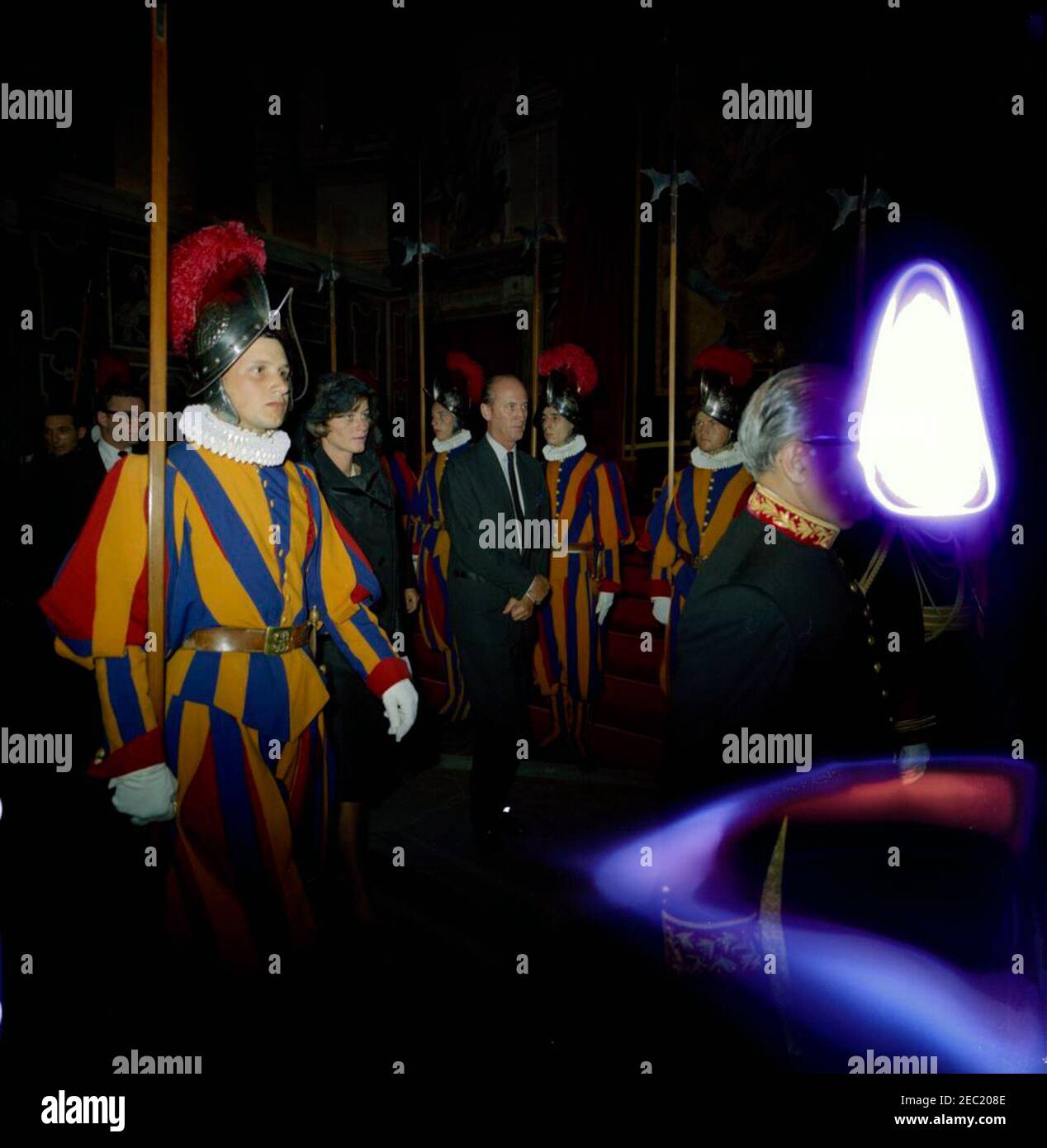 Europareise: Vatikanstadt: Präsident Kennedy im Vatikan. Jean Kennedy Smith, Staatssekretär Dean Rusk, und Pressesekretär Pierre Salinger, 10:00am Uhr. Jean Kennedy Smith geht durch die Clementine Hall des Apostolischen Palastes während Präsident John F. Kennedyu2019s Besuch im Vatikan mit Papst Paul VI. Zu treffen US-Chef des Protokolls, Angier Biddle Duke, geht in der Mitte. Mitglieder der Schweizer Garde beobachten. Vatikanstadt. [Flecken auf dem Bild sind dem Negativen Original.] Stockfoto