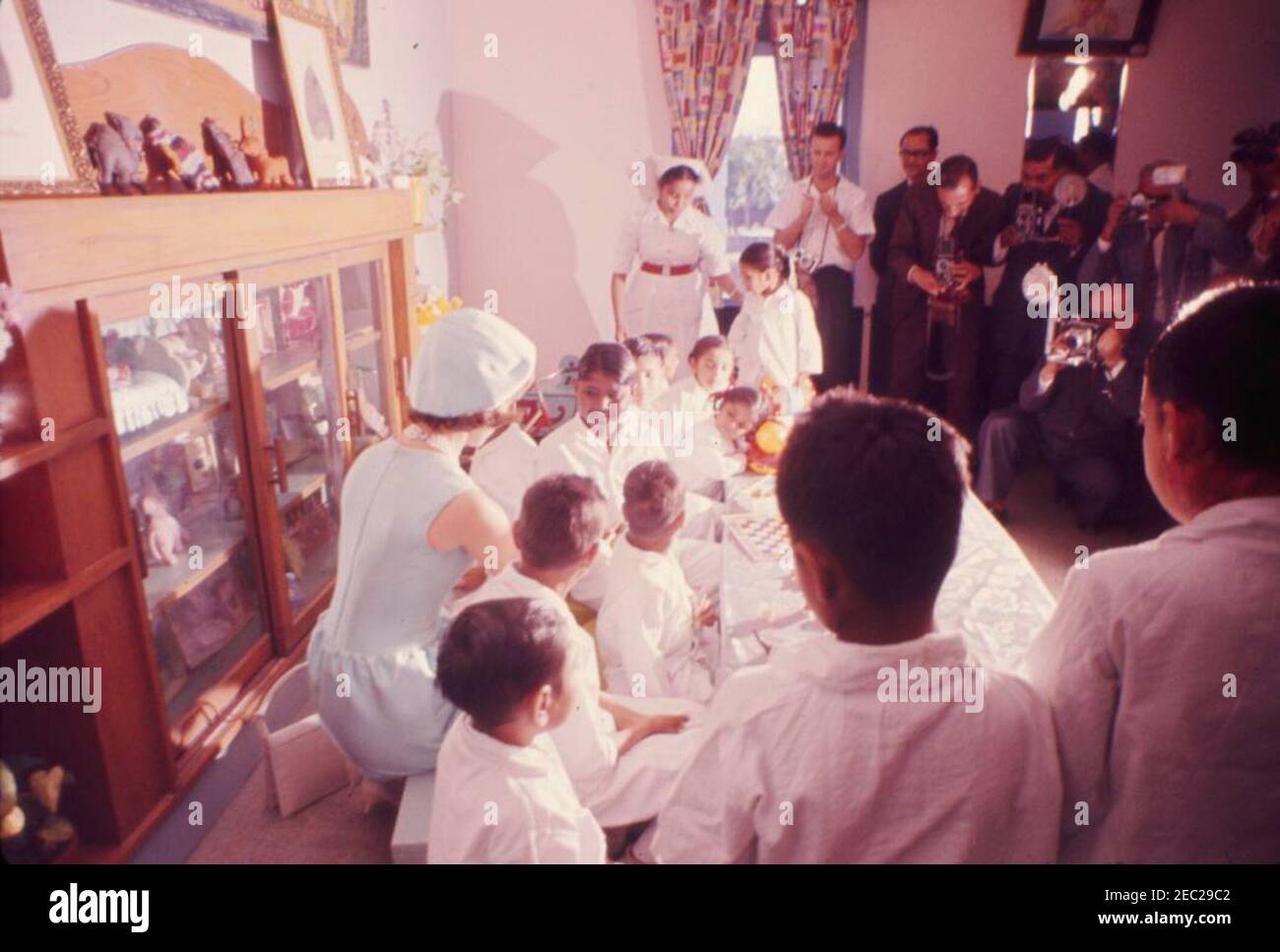 First Lady Jacqueline Kennedyu2019s (JBK) Reise nach Indien und Pakistan: Neu Delhi, Delhi, Indien, Besuch in der Krankenstation, All-India Institute of Medical Sciences. First Lady Jacqueline Kennedy (kniend links) besucht Patienten in der Abteilung childrenu2019s des All-India Institute of Medical Sciences in Neu Delhi, Indien. Stockfoto