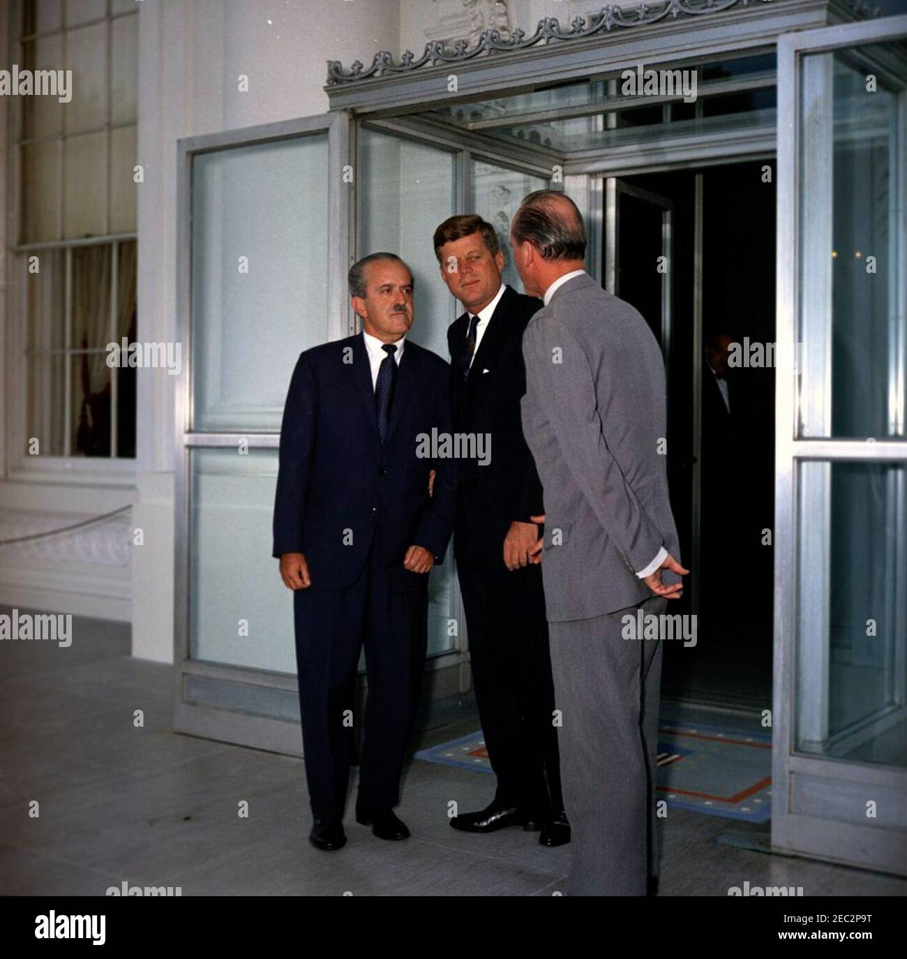 Mittagessen zu Ehren von Guillermo Leon Valencia, designierter Präsident Kolumbiens, 1:00pm Uhr. Präsident John F. Kennedy und der designierte Präsident Kolumbiens, Dr. Guillermo Leu00f3n Valencia (links), besuchen vor einem Mittagessen zu Ehren des designierten Präsidenten Valencia den US-Protokollführer Angier Biddle Duke (rechts). North Portico, White House, Washington, D.C. Stockfoto