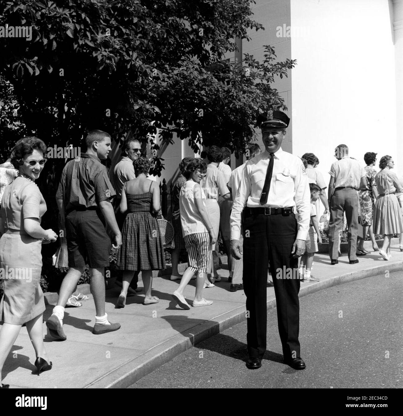 Chef der Polizei des Weißen Hauses, Major Ralph C. u0022Smokeyu0022 Stover, mit Besuchern. Der Chef der Polizei des Weißen Hauses, Major Ralph C. u0022Smokeyu0022 Stover, beobachtet, wie Besucher vor dem Eingang Visitoru2019s warten. Ostflügel, weißes Haus, Washington, D.C. Stockfoto