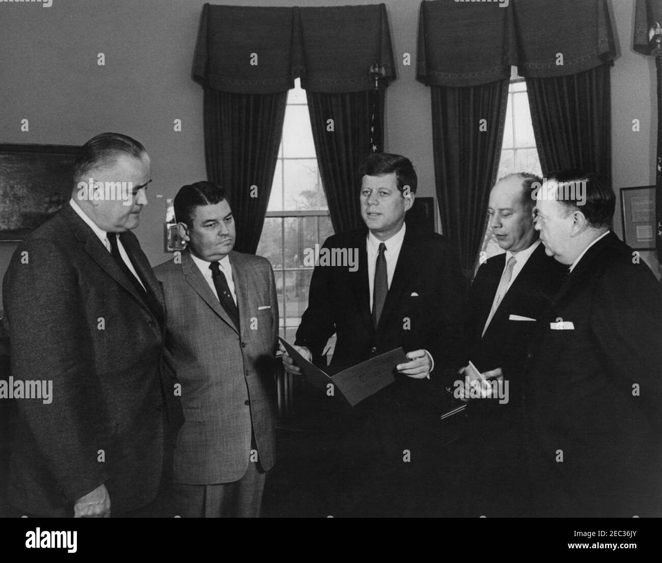 Besuch der Vertreter der Nationalen Konferenz der Staats-Legislative Führer, 11:19am. Vertreter der National Conference of State Legislative Leaders (NCSLL) halten eine Einladung an Präsident John F. Kennedy ab, um an der Konferenz im Juni 1962 in Seattle, Washington, teilzunehmen. (L-R) A. Gordon Boone, Mehrheitsführer des Abgeordnetenhauses von Maryland; William H. Perkins, Jr., von der Continental Casualty Company; Präsident Kennedy; Richard J. Roth vom Senat des Staates New York und Assistent des Präsidenten des NCSLL; und Walter Ou0027Brien vom Senat des Staates Illinois. Oval Office, White Ho Stockfoto