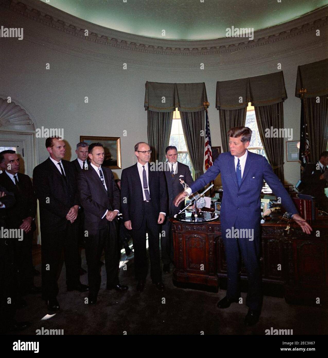Besuch von Beamten der National Aeronautics and Space Administration (NASA), die am Mariner II Projekt beteiligt waren, 12:25pm Uhr. Präsident John F. Kennedy (rechts, gestikuliert mit verlängerten Waffen) Besuche bei Beamten der National Aeronautics and Space Administration (NASA), die ihm ein Modell der Raumsonde Mariner 2 (auf dem Schreibtisch Presidentu0027s) überreichten. Von links nach rechts: Edgar M. Cortright, stellvertretender Direktor des NASAu0027s Office of Space Sciences; Jack N. James, Projektleiter von Mariner 2 für NASAu0027s Jet Propulsion Lab (JPL); Dr. Robert C. Seamans, Jr., Associate Administrator der NASA (im Hintergrund); Rob Stockfoto