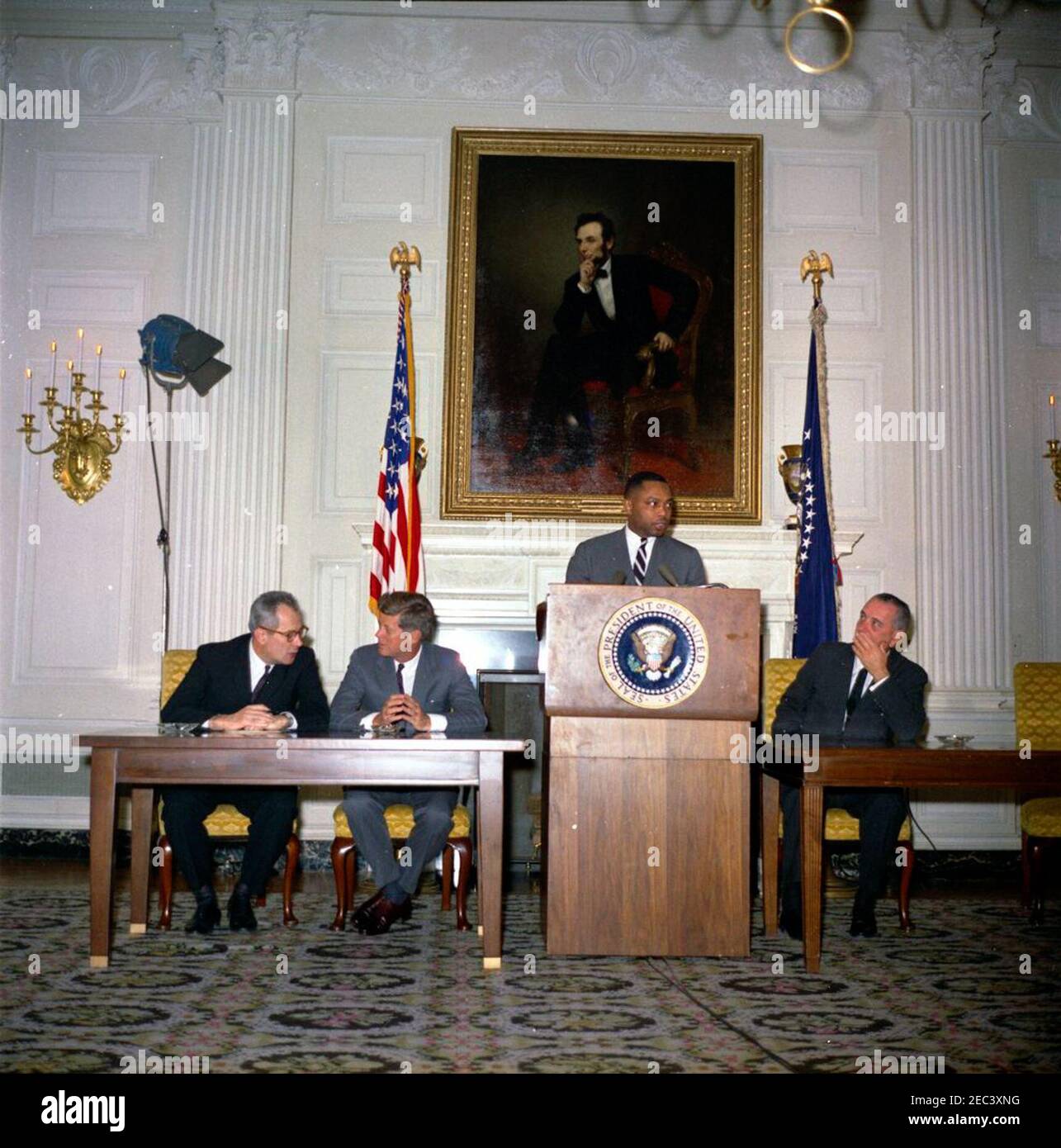 Unterzeichnungszeremonie, Pläne für Fortschritte - der Ausschuss für gleiche Beschäftigungsmöglichkeiten Presidentu0027s, 4:40pm. Hobart Taylor, Jr., Executive Vice Chairman des Ausschusses für Chancengleichheit (PCEEO) Presidentu0027s, spricht bei einer Unterzeichnungszeremonie für die Pläne für Fortschritte; Beamte von zwanzig Unternehmen unterzeichneten im Rahmen des Programms Arbeitsverträge für Chancengleichheit. Von links nach rechts: Arbeitsminister W. Willard Wirtz; Präsident John F. Kennedy; Herr Hobart; Vizepräsident Lyndon B. Johnson. State Dining Room, White House, Washington, D.C. Stockfoto