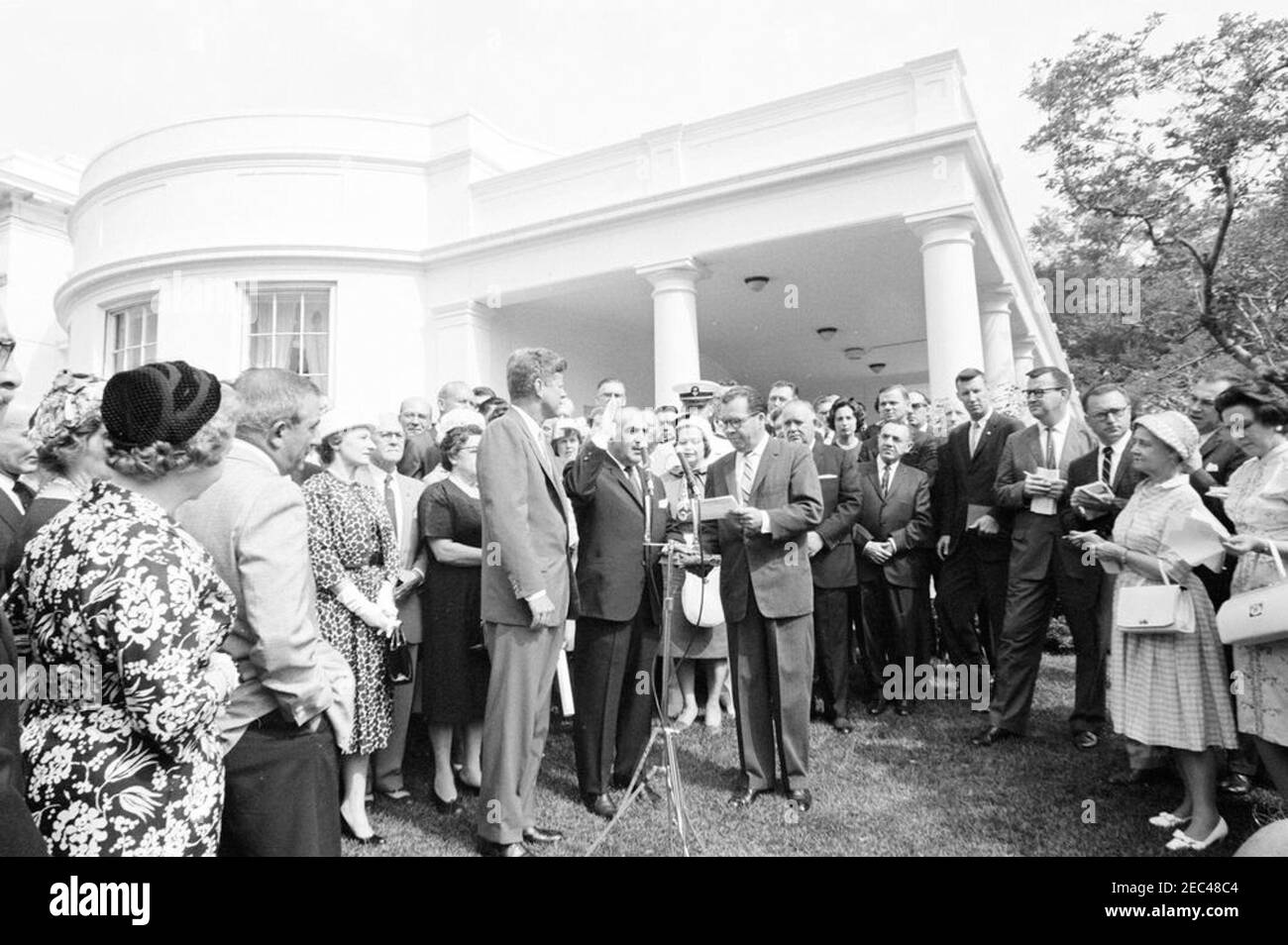 Vereidigung, Sekretär für Gesundheit, Bildung und Wohlfahrt (HEW) Anthony Celebrezze, 10:12am Uhr. Präsident John F. Kennedy beobachtet, wie Anthony J. Celebrezze als Sekretär für Gesundheit, Bildung und Wohlfahrt vereidigt wird; der Verwaltungsbeamte des Weißen Hauses, Carson M. Howell, verwaltet den Eid. Ebenfalls im Bild: Anne Celebrezze; Midshipman First Class Anthony J. Celebrezze, Jr.; Washington-Korrespondent der Guy Gannet Publishing Company of Maine, May Craig; White House Secret Service Agent, Jim Johnson. West Wing Lawn, White House, Washington, D.C. [Bitte beachten Sie den Zeitplan für Presidentu2019s f Stockfoto