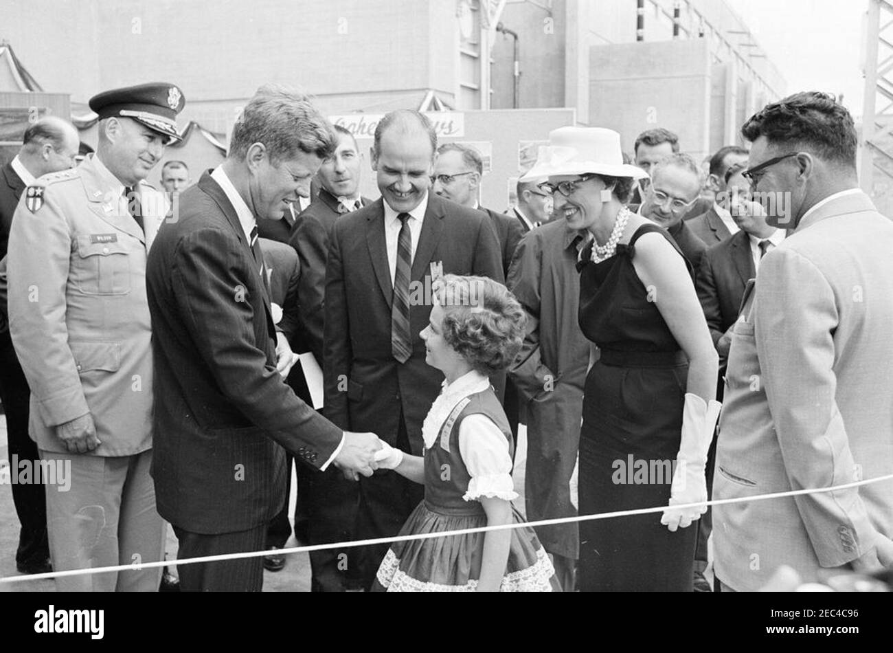 Reise in die westlichen Staaten: Pierre, South Dakota (Oahe Dam), 10:25am Uhr. Präsident John F. Kennedy schüttelt die Hände mit Jamie Damon, Pierre, South Dakota, während der Zeremonie der Einweihung des Oahe Dam und Reservoir, am Ufer des Missouri River, in der Nähe von Pierre, South Dakota. US-Senatorenkandidat aus South Dakota, George McGovern (Mitte) und Jamieu0027s Mutter, Dottie Damon (rechts), schauen Sie auf. Ebenfalls abgebildet: Chef der Armeeingenieure, Generalleutnant Walter K. Wilson, Jr.; Innenminister Stewart L. Udall; Geheimagent des Weißen Hauses, Jerry Blaine. Stockfoto