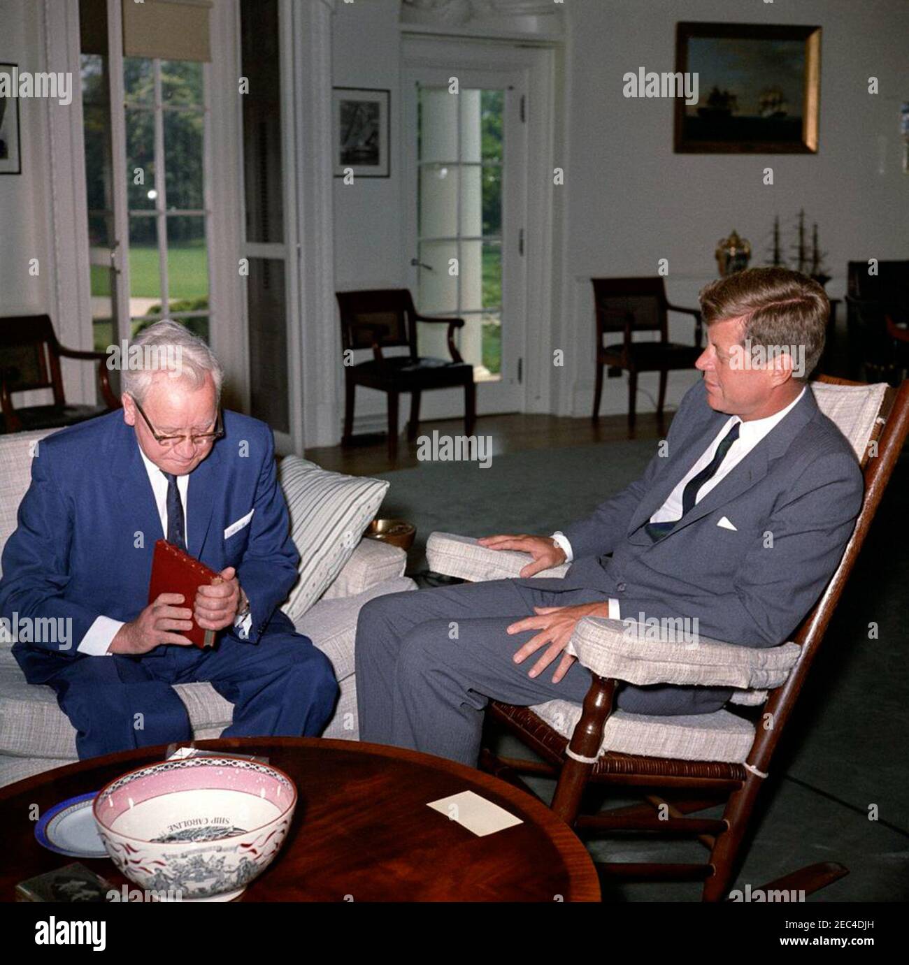 Treffen mit Herbert, Lord Morrison, Präsident, British Board of Film Censors, 12:16pm Uhr. Präsident John F. Kennedy (im Schaukelstuhl) trifft sich mit dem Präsidenten des British Board of Film Censors, Lord Herbert Morrison von Lambeth. Lord Morrison schaut sich ein Buch an, während Präsident Kennedy auf sich schaut. Oval Office, White House, Washington, D.C. Stockfoto