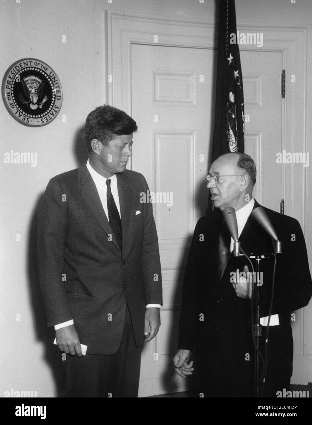 Bemerkungen an die Presse bezüglich einer Einladung zur Medical Care for the Aged Rally, die um 12:00pm Uhr im Madison Square Garden stattfindet. Präsident des Nationalrats der Senioren und ehemaliger Kongressabgeordneter von Rhode Island, Aime J. Forand (rechts), lädt Präsident John F. Kennedy ein, an einer medizinischen Versorgung für die gealterte Kundgebung im Madison Square Garden in New York City teilzunehmen. Fish Room (Konferenzraum), White House, Washington, D.C. Stockfoto