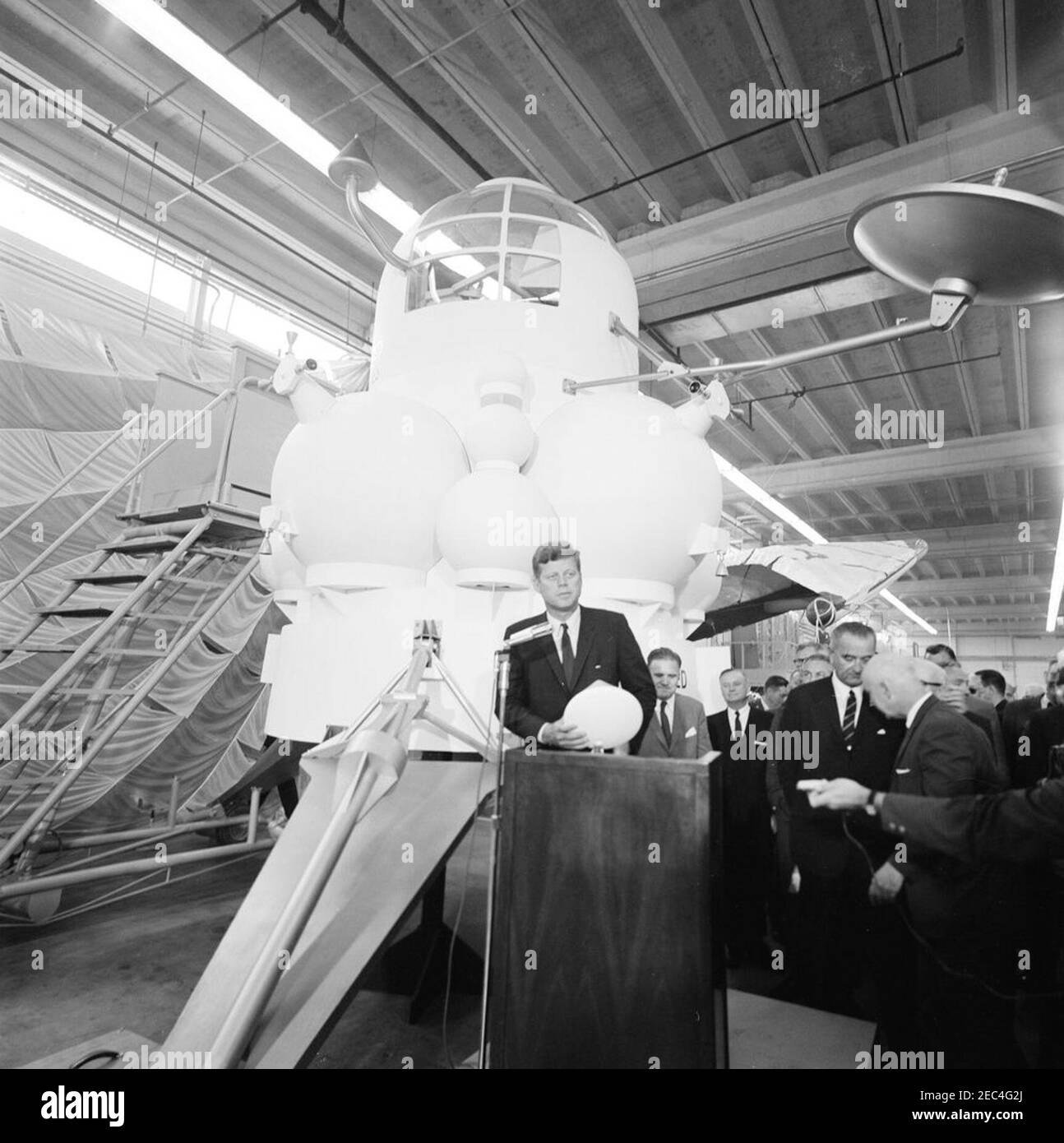 Besichtigung der NASA-Installationen: Houston, Texas, NASA Rich Building, Abfahrt, 11:10am Uhr. Präsident John F. Kennedy (am Rednerpult) hält Bemerkungen, nach einer Tour von Raumfahrzeugen zeigt in einem Hangar im Rich Building des bemannten Raumschiffszentrums, Houston, Texas. Präsident Kennedy hält ein maßstabsgetreues Modell des Apollo-Kommandomoduls, das ihm vom Direktor des bemannten Raumschiffszentrums, Dr. Robert Gilruth, vorgestellt wurde; ein Modell des Mondlanders (auch bekannt als u0022the Bugu0022) sitzt im Hintergrund. Im Hintergrund: Administrator der Nationalen Luft- und Raumfahrtbehörde ( Stockfoto