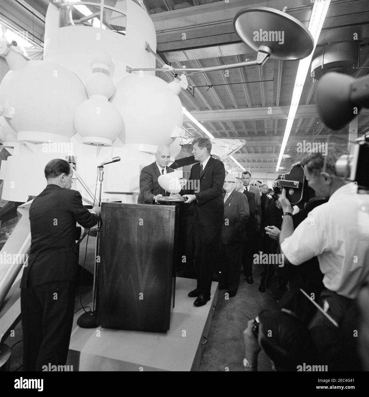 Besichtigung der NASA-Installationen: Houston, Texas, NASA Rich Building, Abfahrt, 11:10am Uhr. Präsident John F. Kennedy erhält ein maßstabsgetreues Modell des Apollo-Kommandomoduls vom Direktor des bemannten Raumschiffszentrums, Dr. Robert Gilruth (am Rednerpult), nach einer Tour der Raumschiffsvorführungen in einem Hangar im Rich Building des bemannten Raumschiffszentrums, Houston, Texas. Im Hintergrund: Gouverneur von Texas, Price Daniel; Senator Alexander Wiley (Wisconsin); Direktor der bemannten Raumfahrt, D. Brainerd Holmes; Direktor der Verteidigungsforschung und -Technik für das Verteidigungsministerium, Dr. Stockfoto