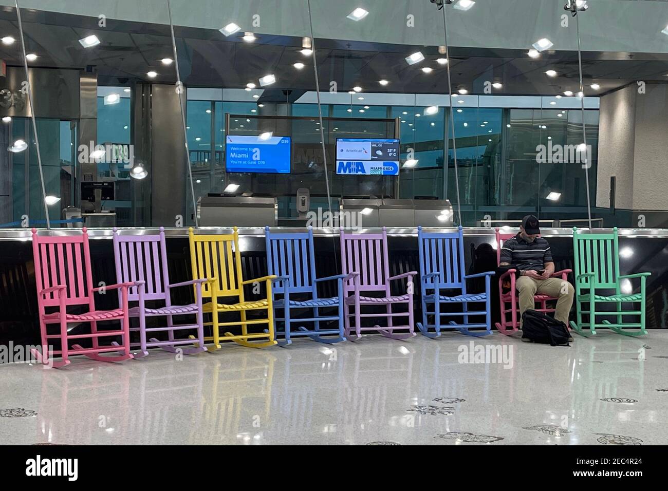 Ein Mann sitzt allein in Terminal D des Miami International Airport, Samstag, 13. Februar 2021, in Miami. Stockfoto