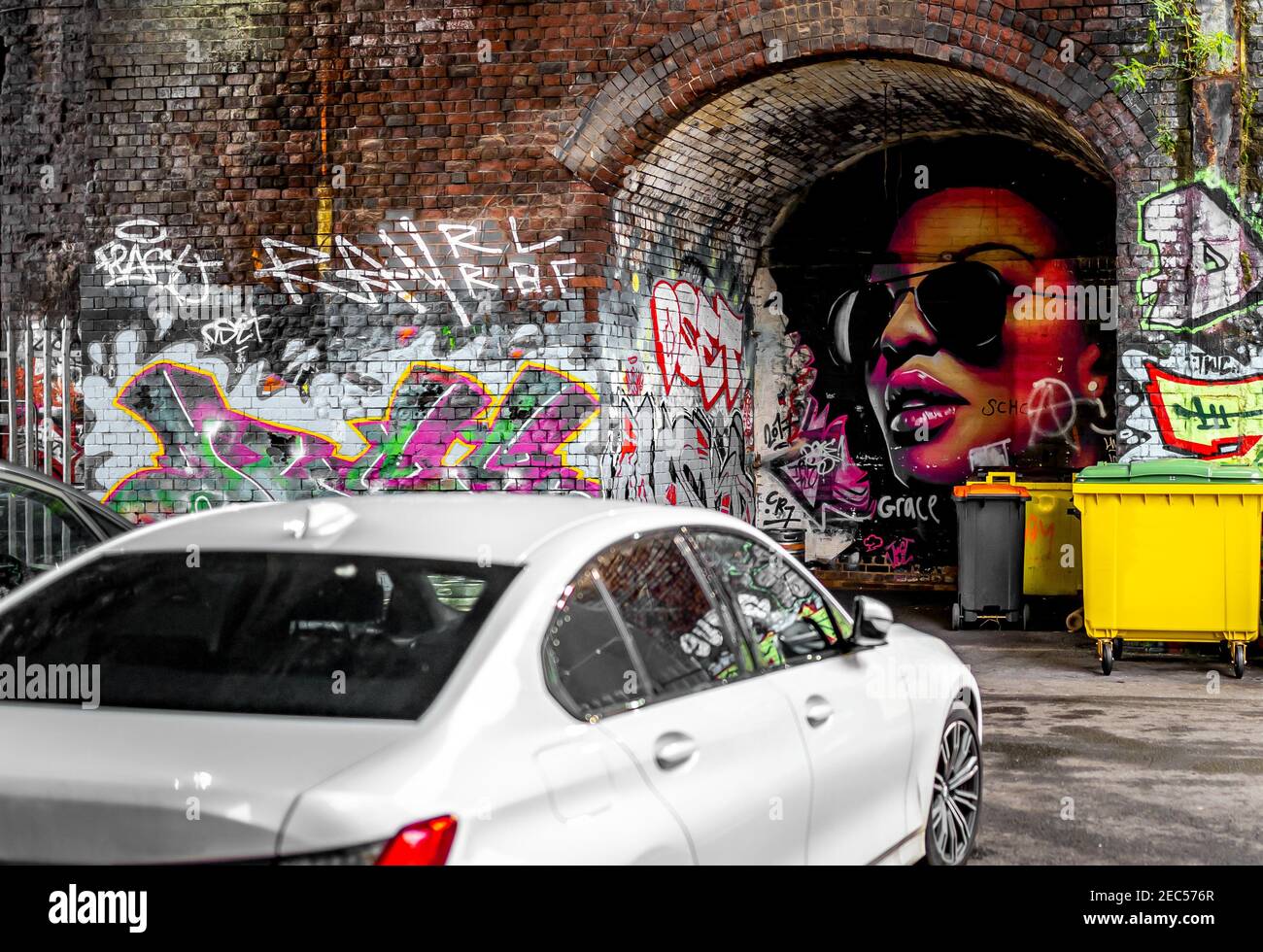 Moderne Stadt professionelle Graffiti Street Art dramatische Farben im Inneren Bogen Von Eisenbahnviadukt in Digbeth Birmingham, das auf Autofenster reflektiert Stockfoto