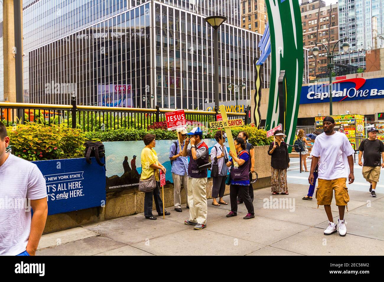 Eine Gruppe von asiatischen Missionaren predigen mit einem Kreuz und Am Eingang stehen Schilder mit der Aufschrift "Jesus ist Heiland" Des Madison Square Garden Stockfoto