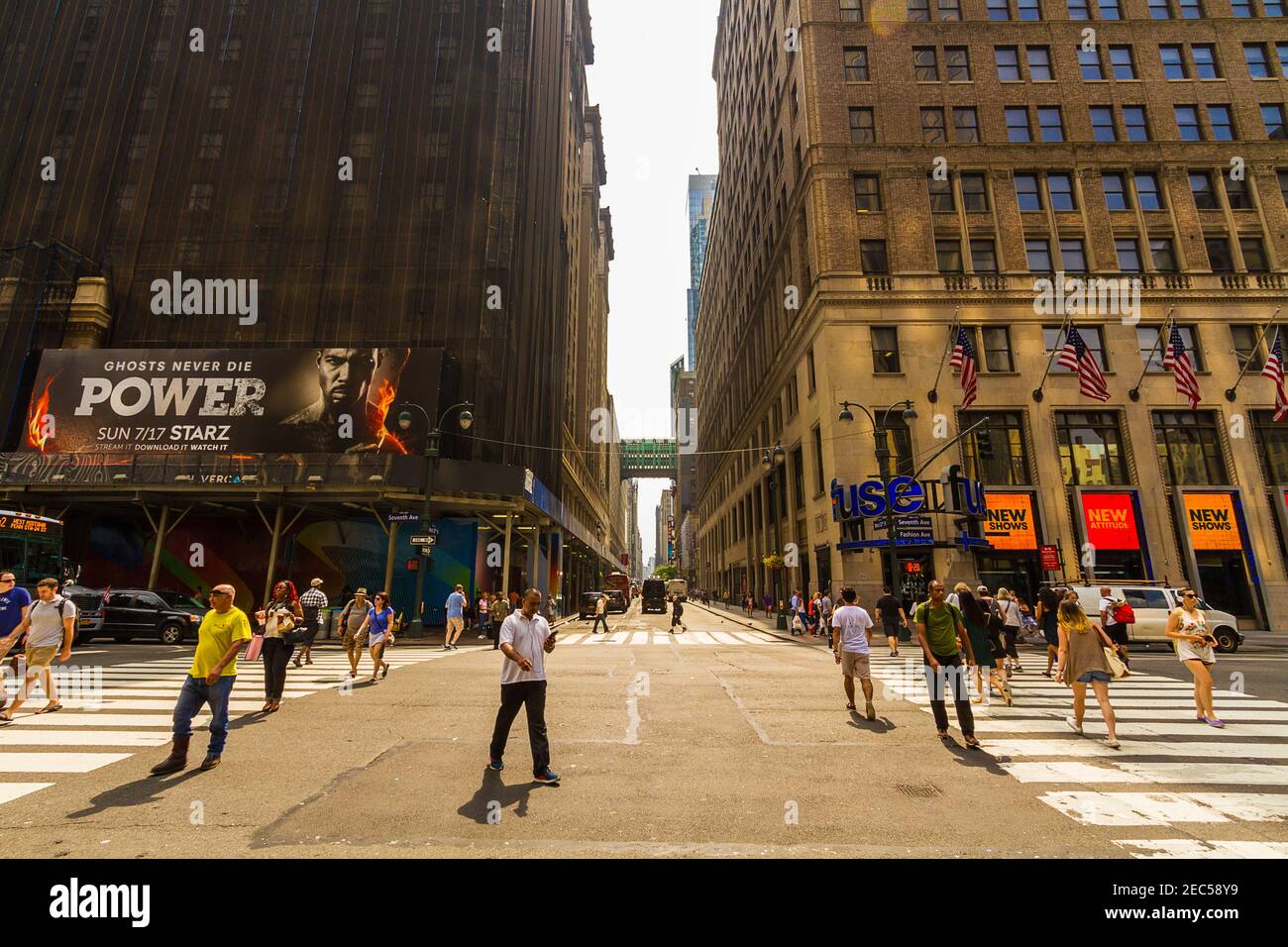 7th Avenue Street in Manhattan, New York City mit Leuten, die die Straße überqueren und mit einer Werbetafel Stockfoto