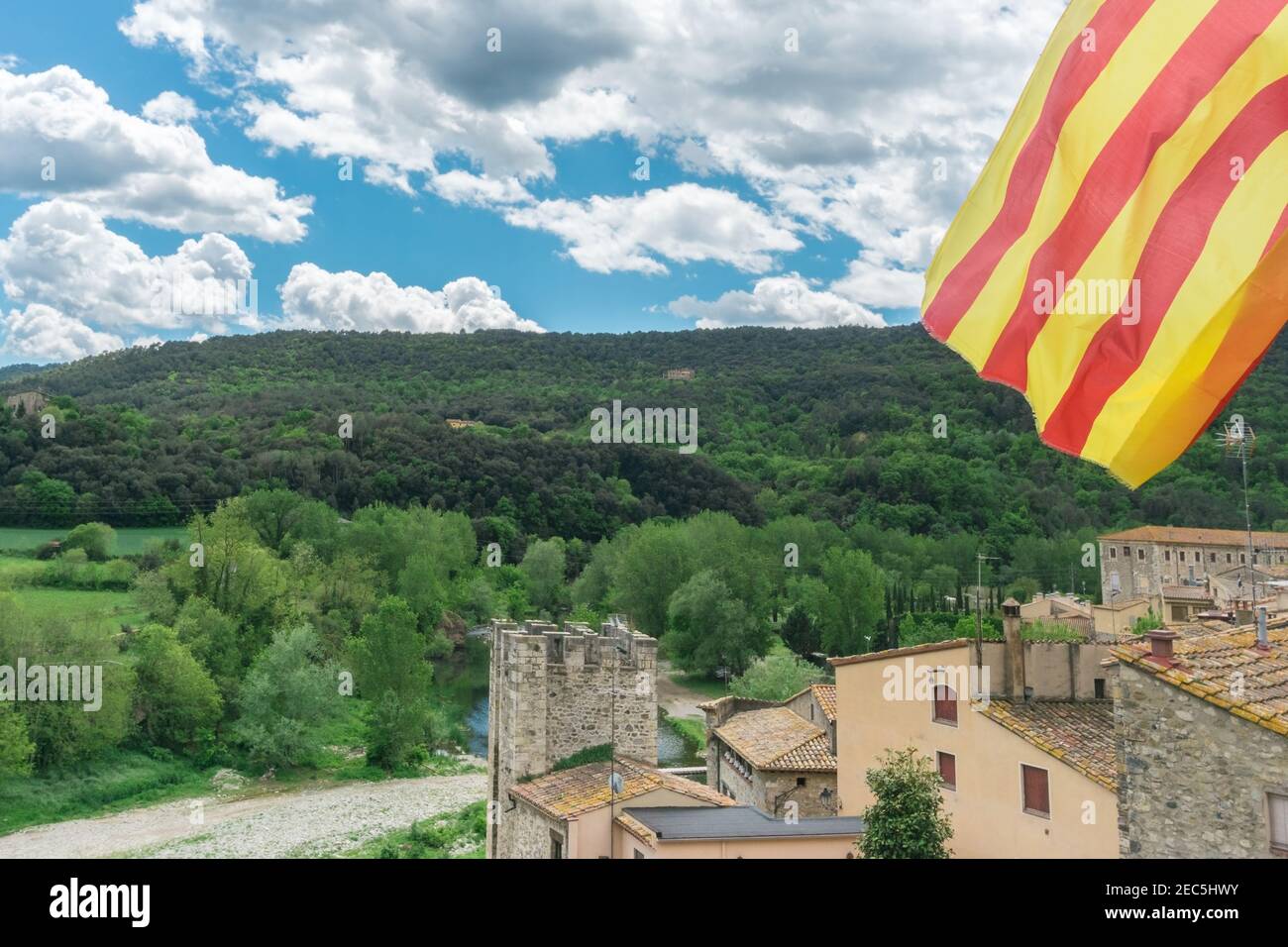 Katalanische Flagge über schöne Aussicht auf Besalu, mittelalterliches Dorf in der Provinz Girona in Katalonien, Spanien. Symbol des Strebens nach Unabhängigkeit Kataloniens Stockfoto