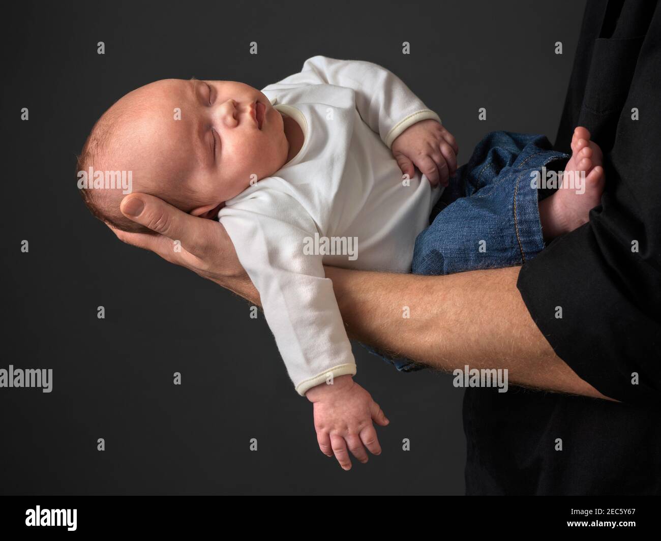 Vater hält Baby Junge schlafen in seinen Armen Stockfoto