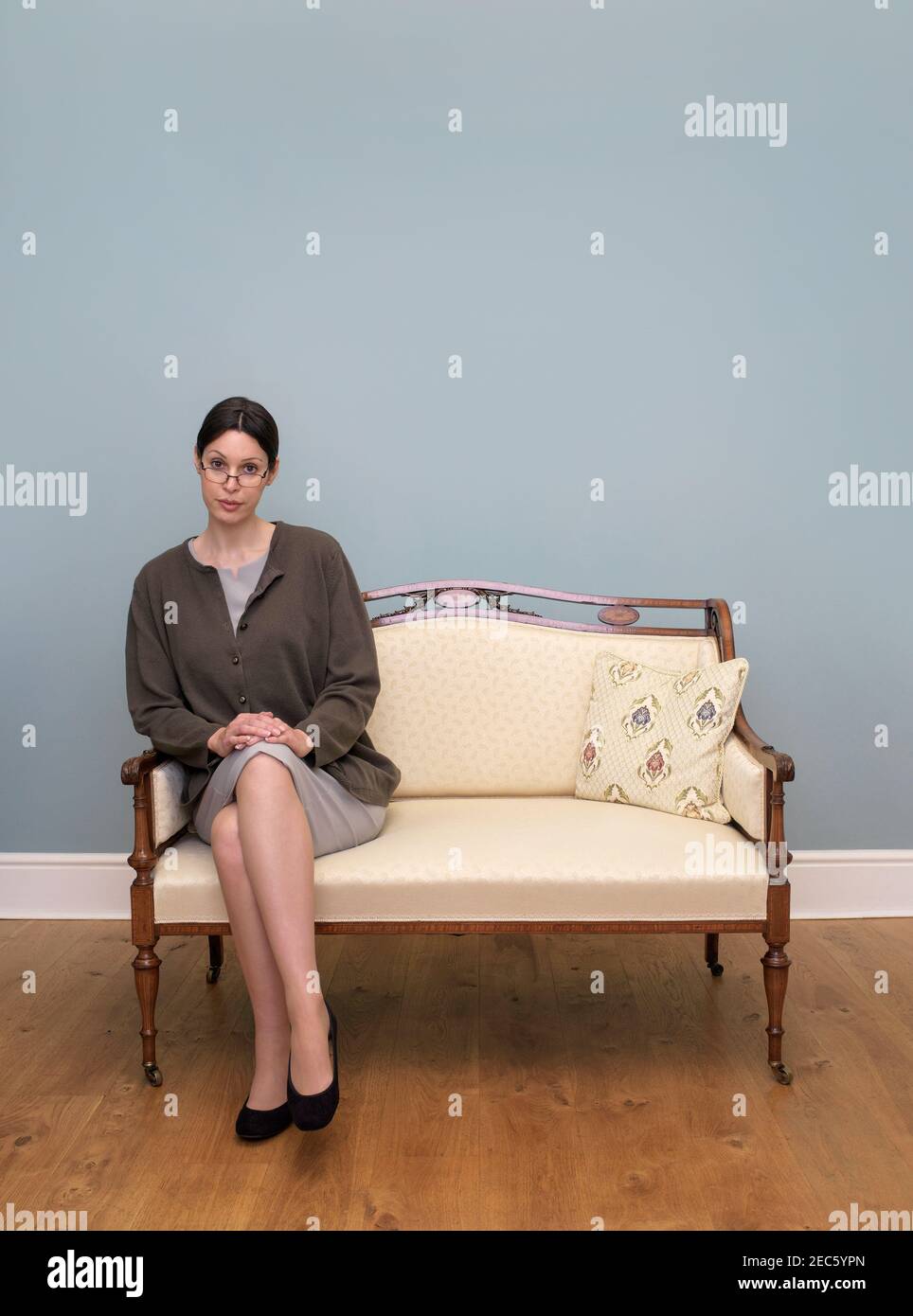 Respektable alleinstehende Frau allein auf einem Sitz für zwei Stockfoto