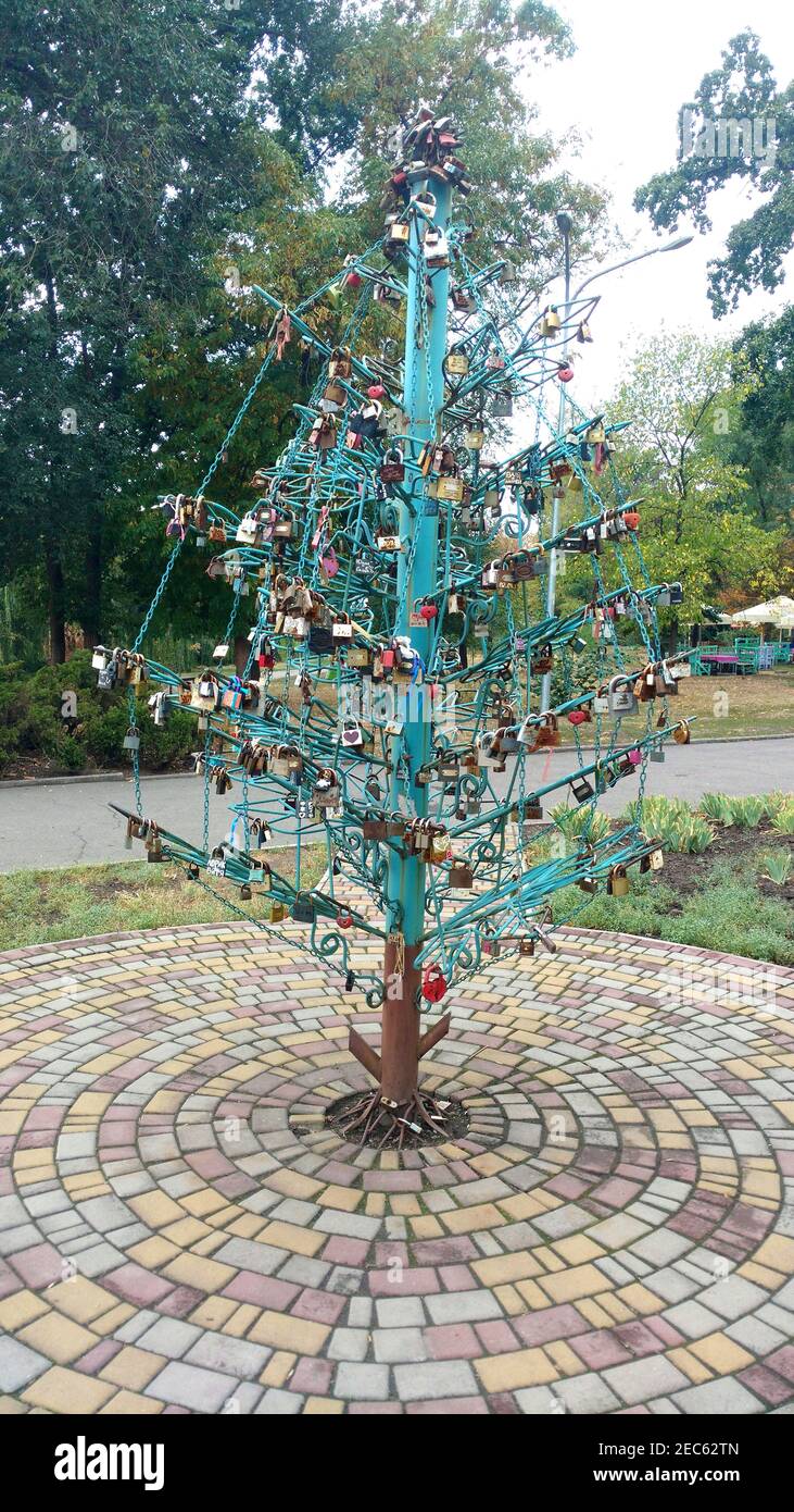 Metallstruktur in Form eines Weihnachtsbaums mit symbolischen Schlössern für Brautpaar im Park. Stockfoto