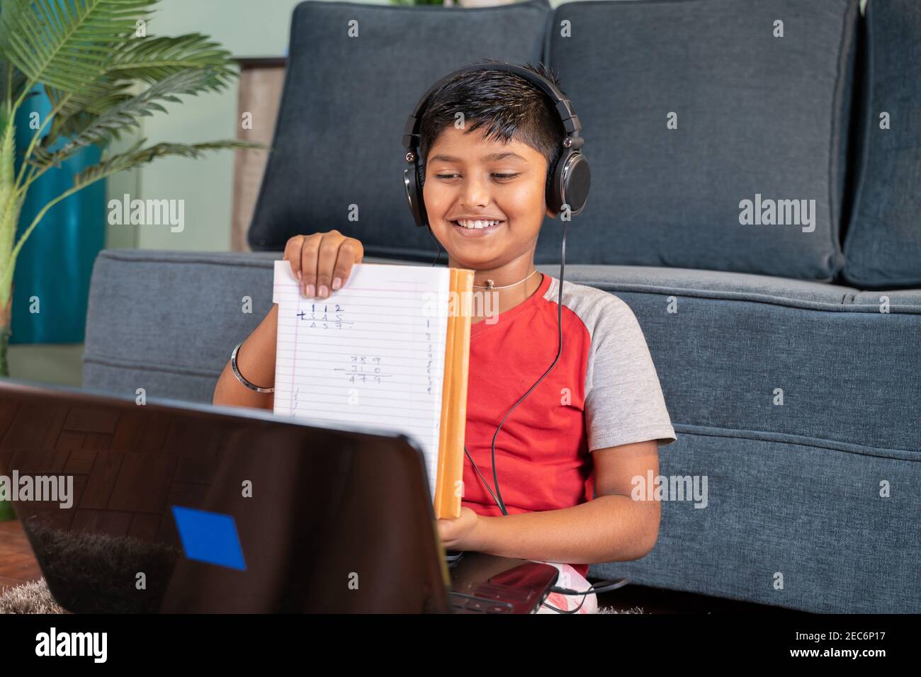 Kind interagiert während des Online-Kurses, indem es gelöste Probleme zeigt Tutor auf Laptop - Konzept der neuen normalen virtuellen Bildung Und E-Learning durch Stockfoto