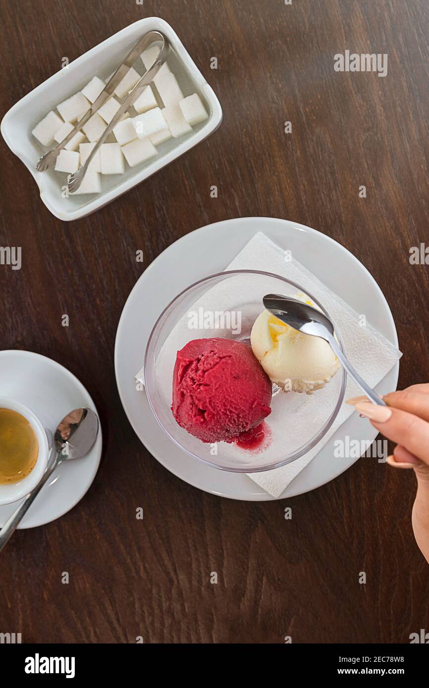 Rote und weiße Kugel Eis. Espresso-Kaffeetasse und Zuckerdose mit Zucker Stockfoto